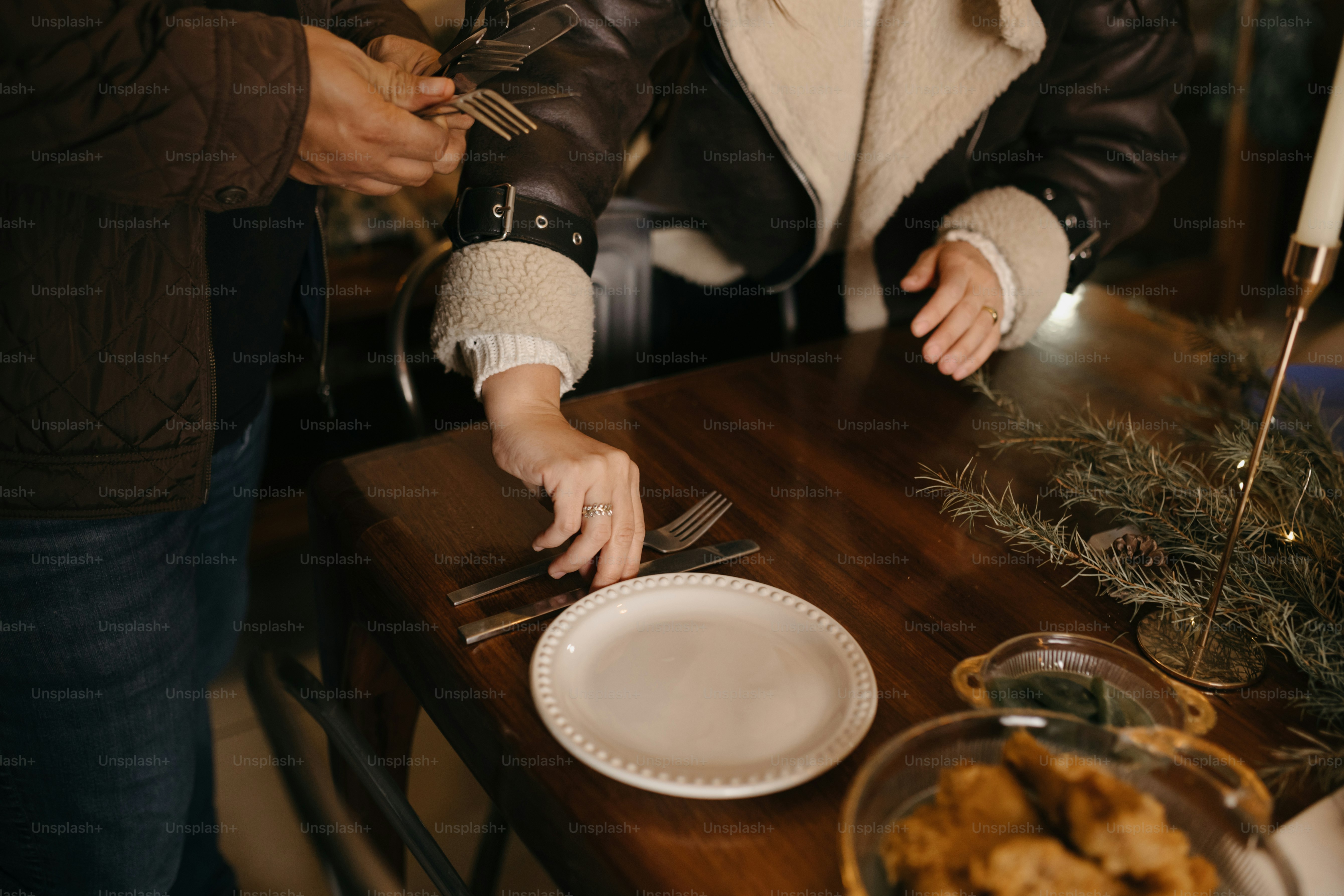 A man and a woman standing at a table with plates of food photo ...
