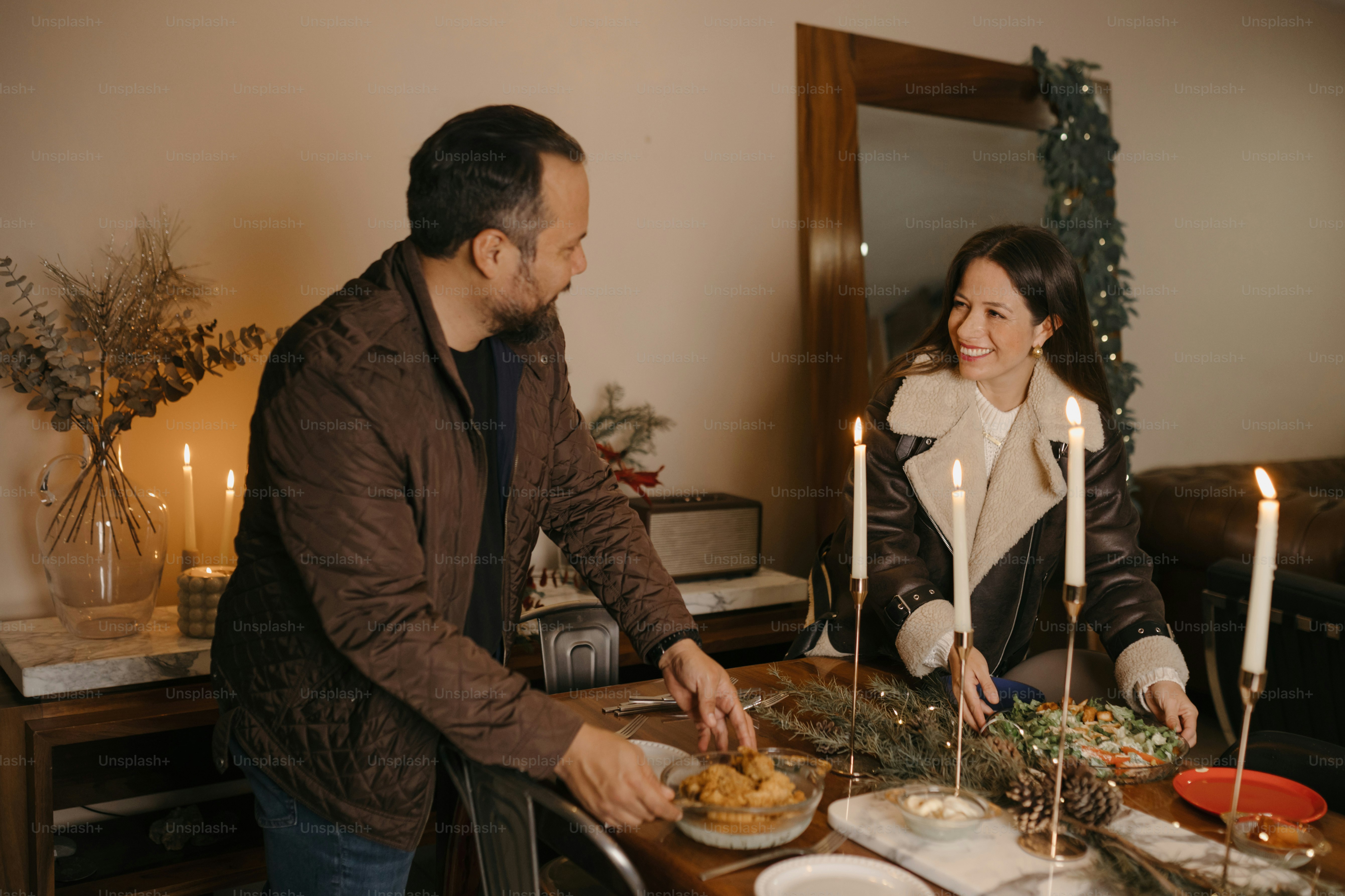 A man and woman standing at a table with plates of food photo – Family ...