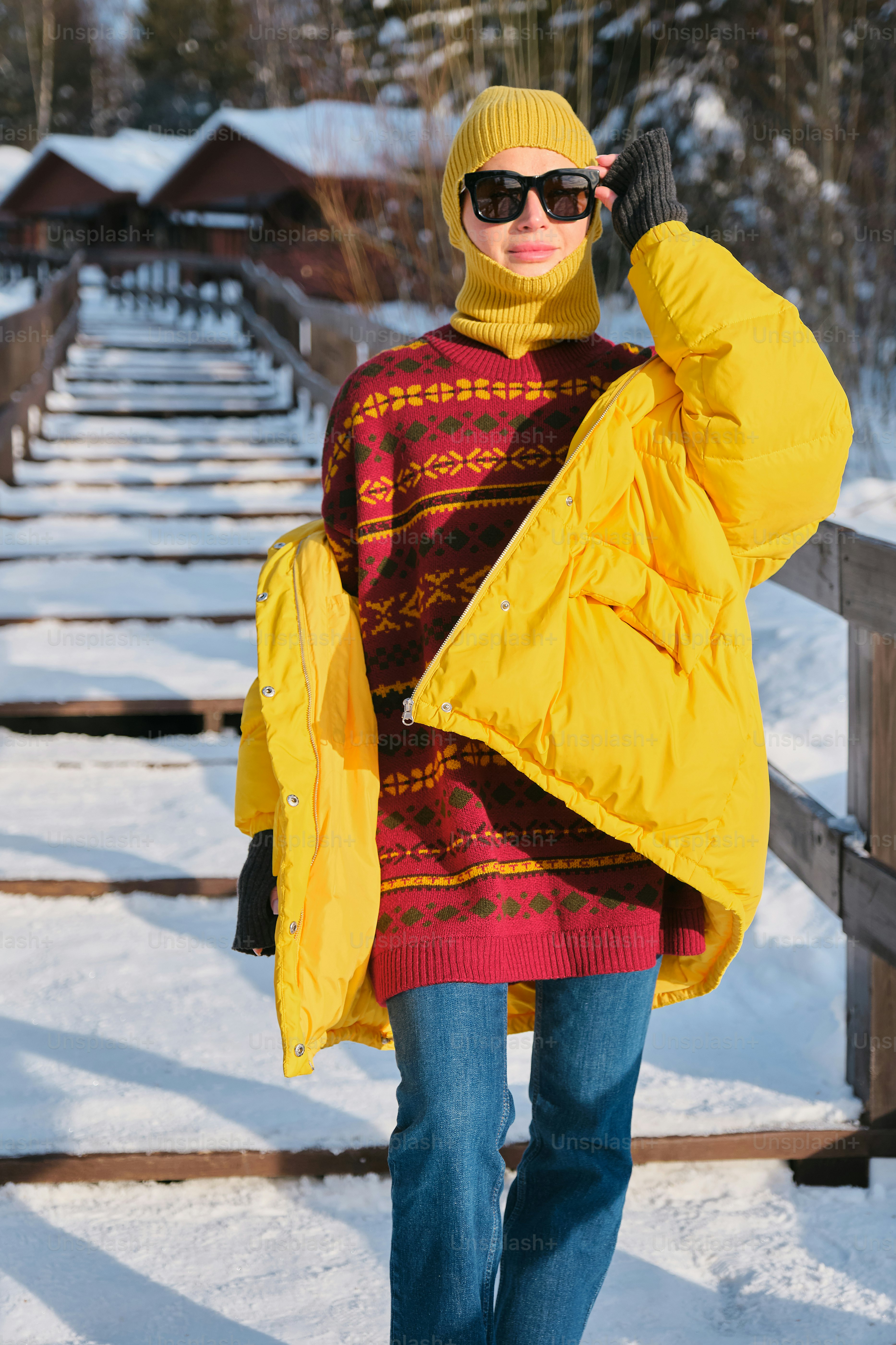 stylish woman in a fashionable winter outfit in a snowy forest in the mountains