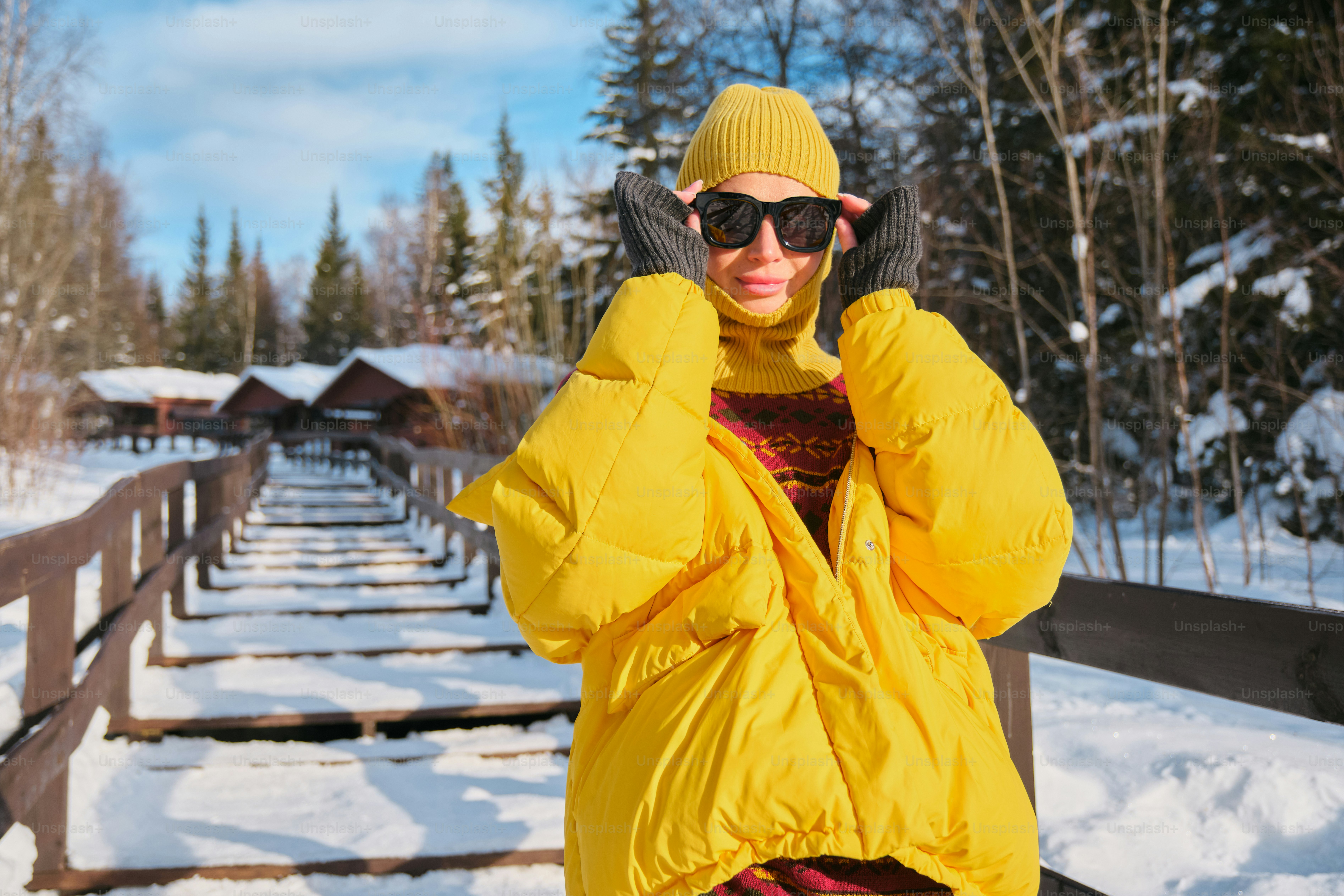 A woman in a yellow jacket is talking on a cell phone