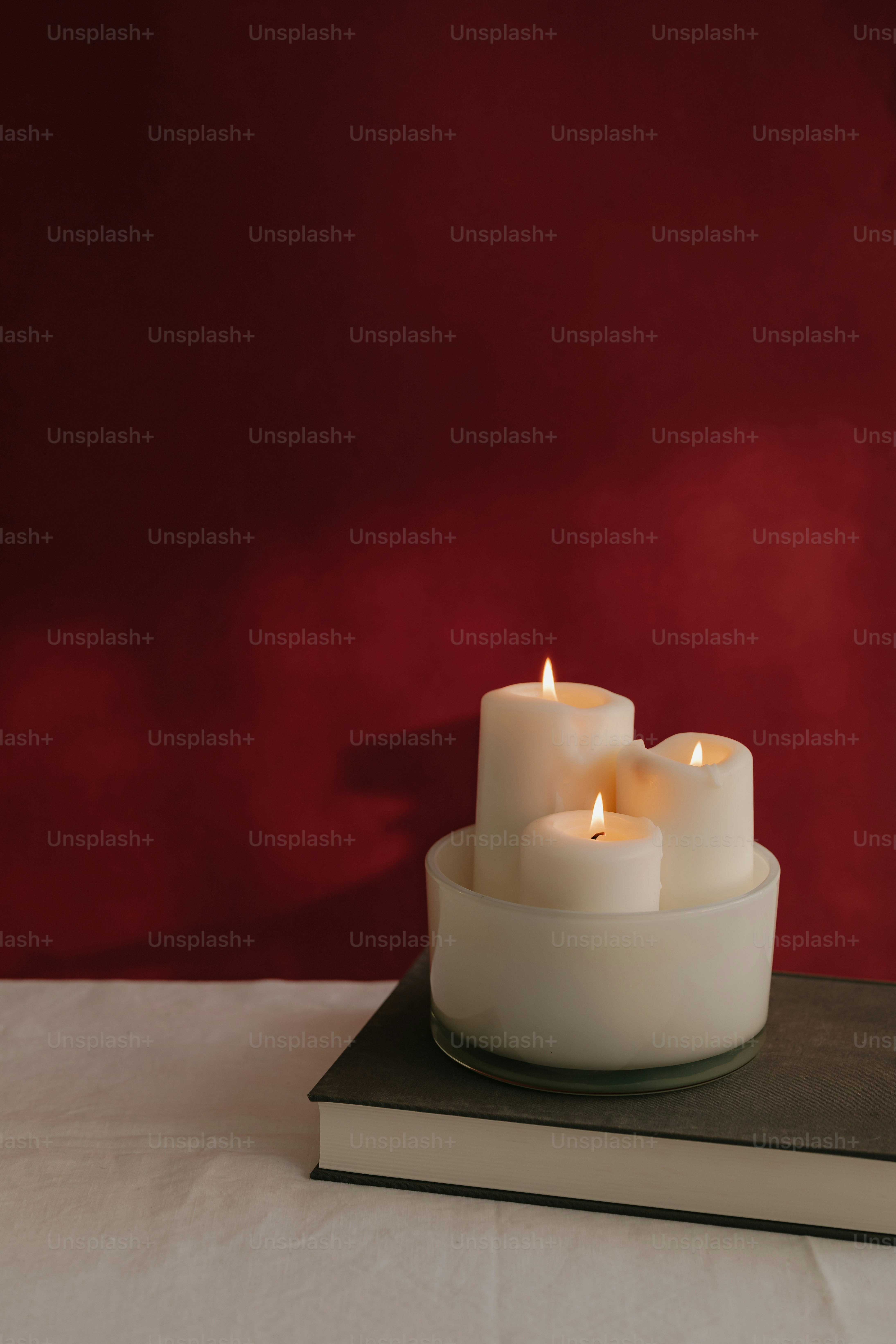 Una candela bianca seduta sopra un libro