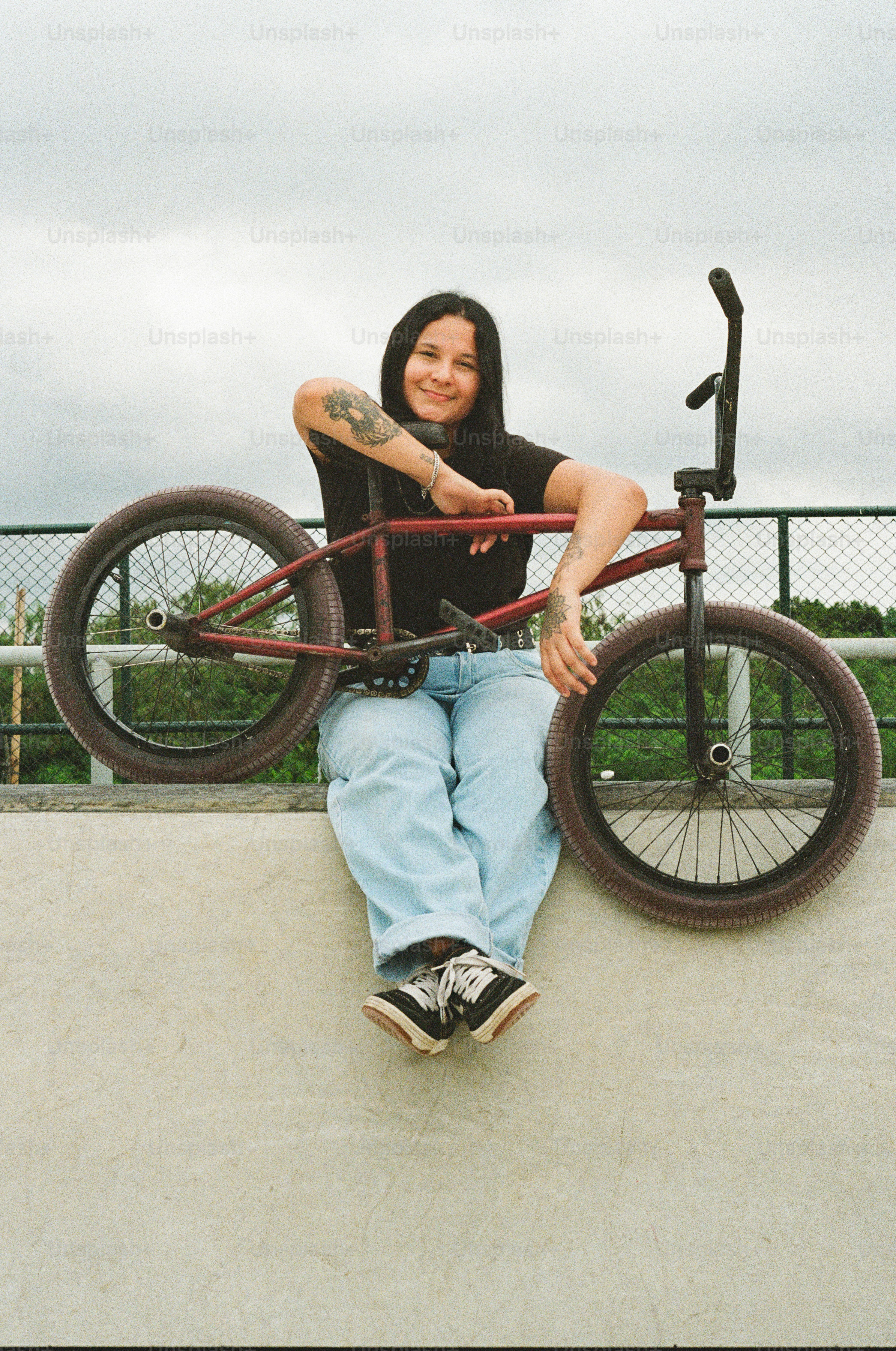 A woman sitting on top of a skateboard ramp