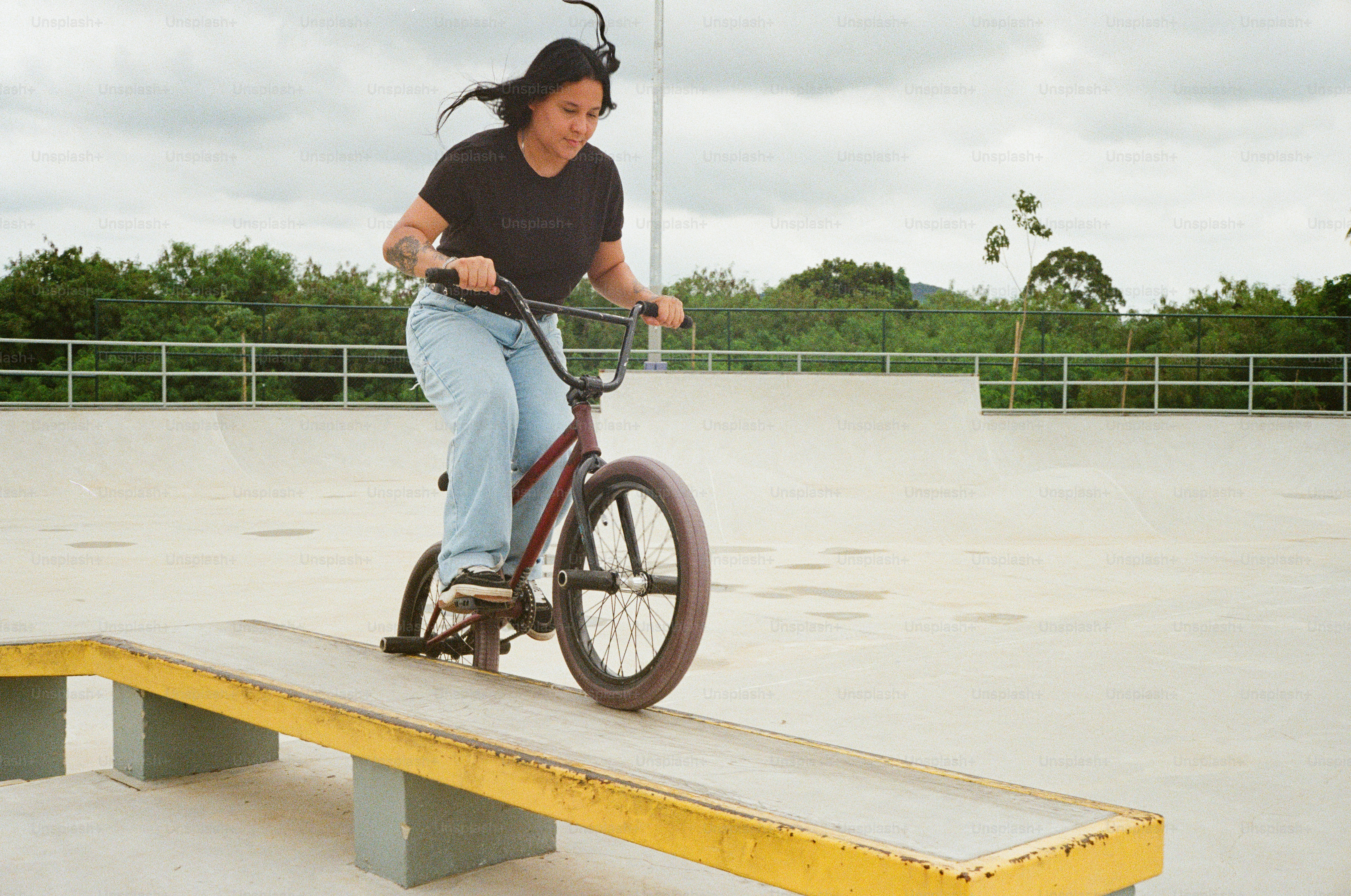 A woman riding a bike on top of a wooden bench