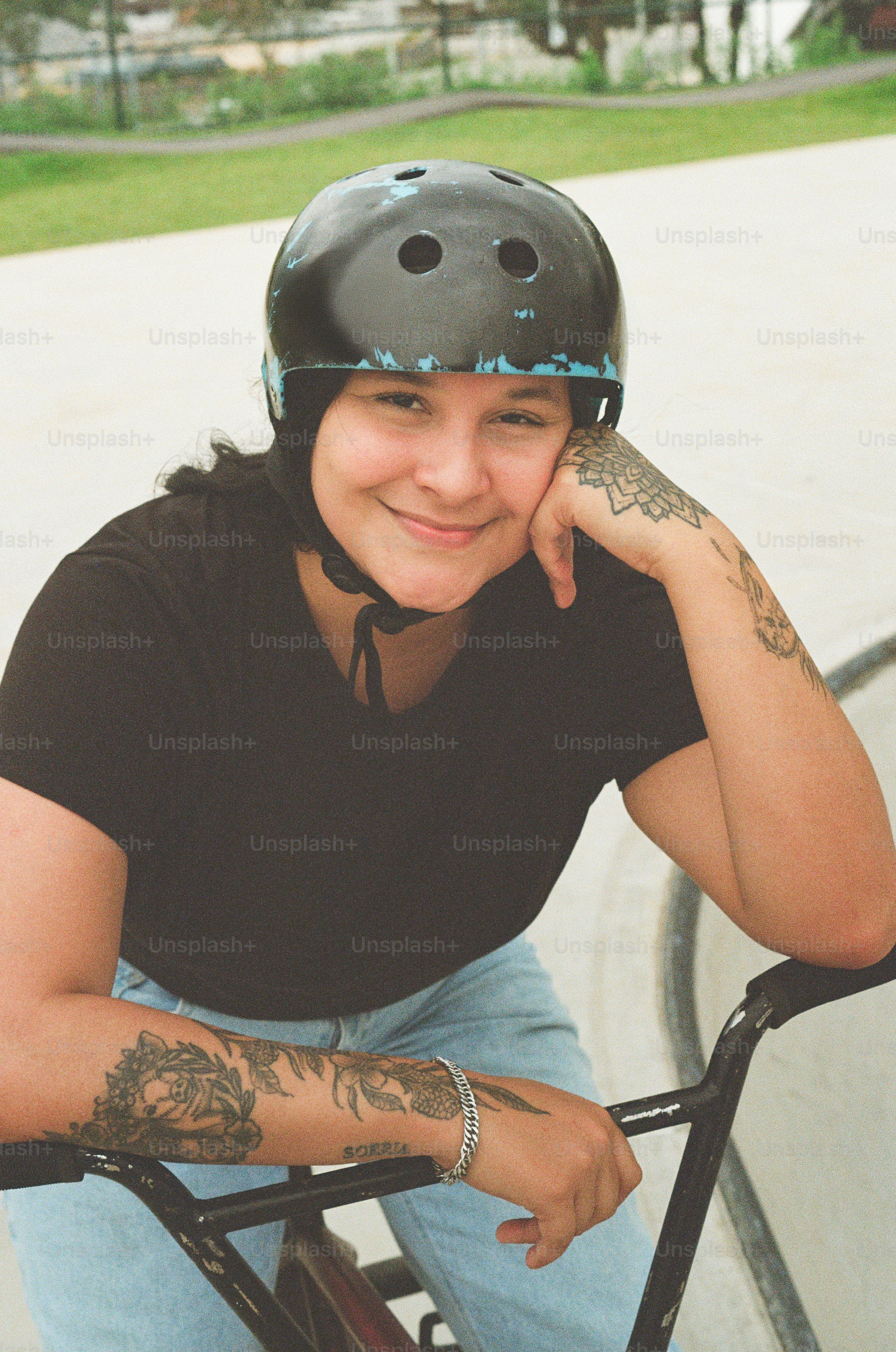 A woman sitting on a bike with a helmet on
