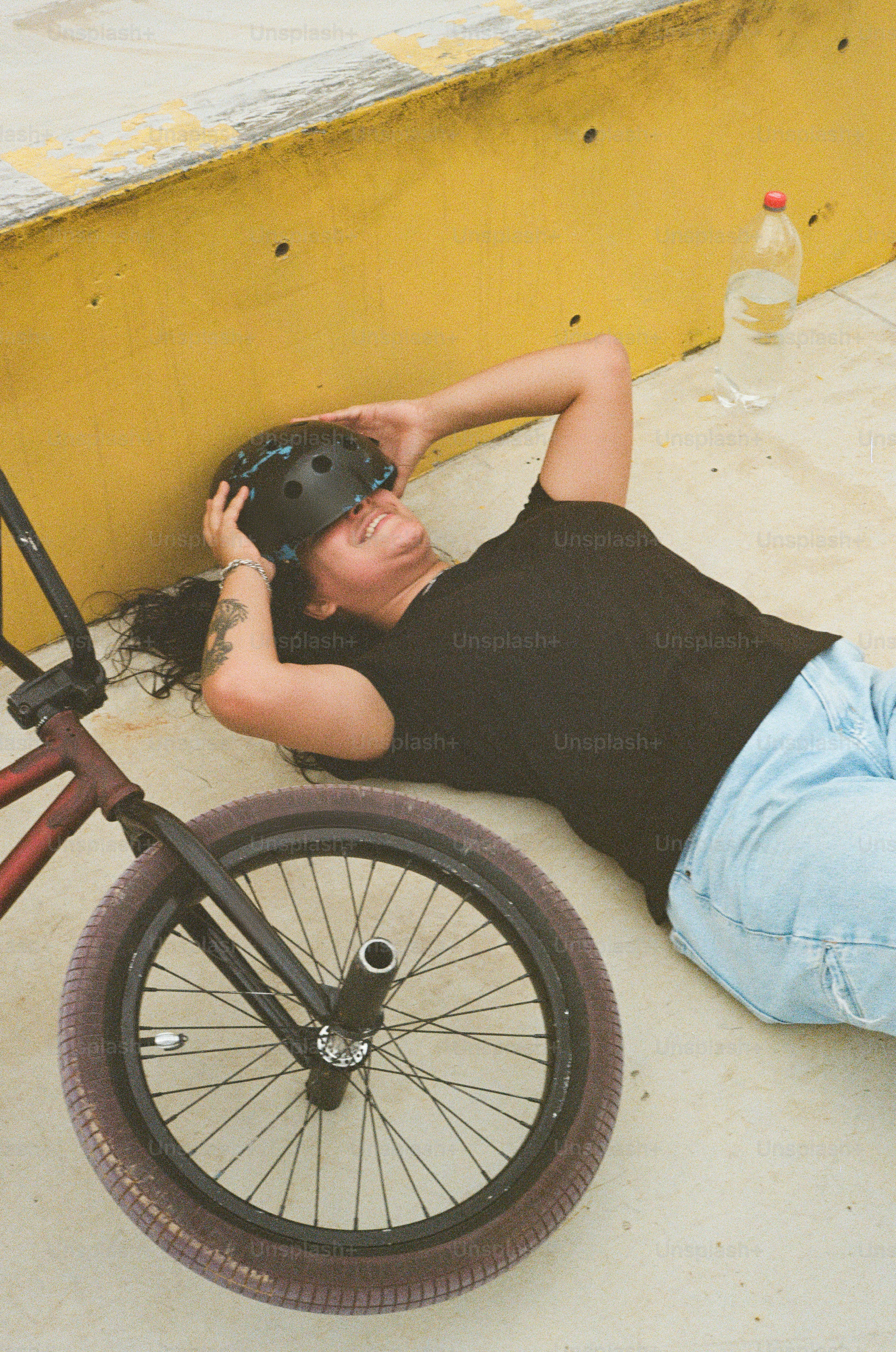 A woman laying on the ground next to a bike