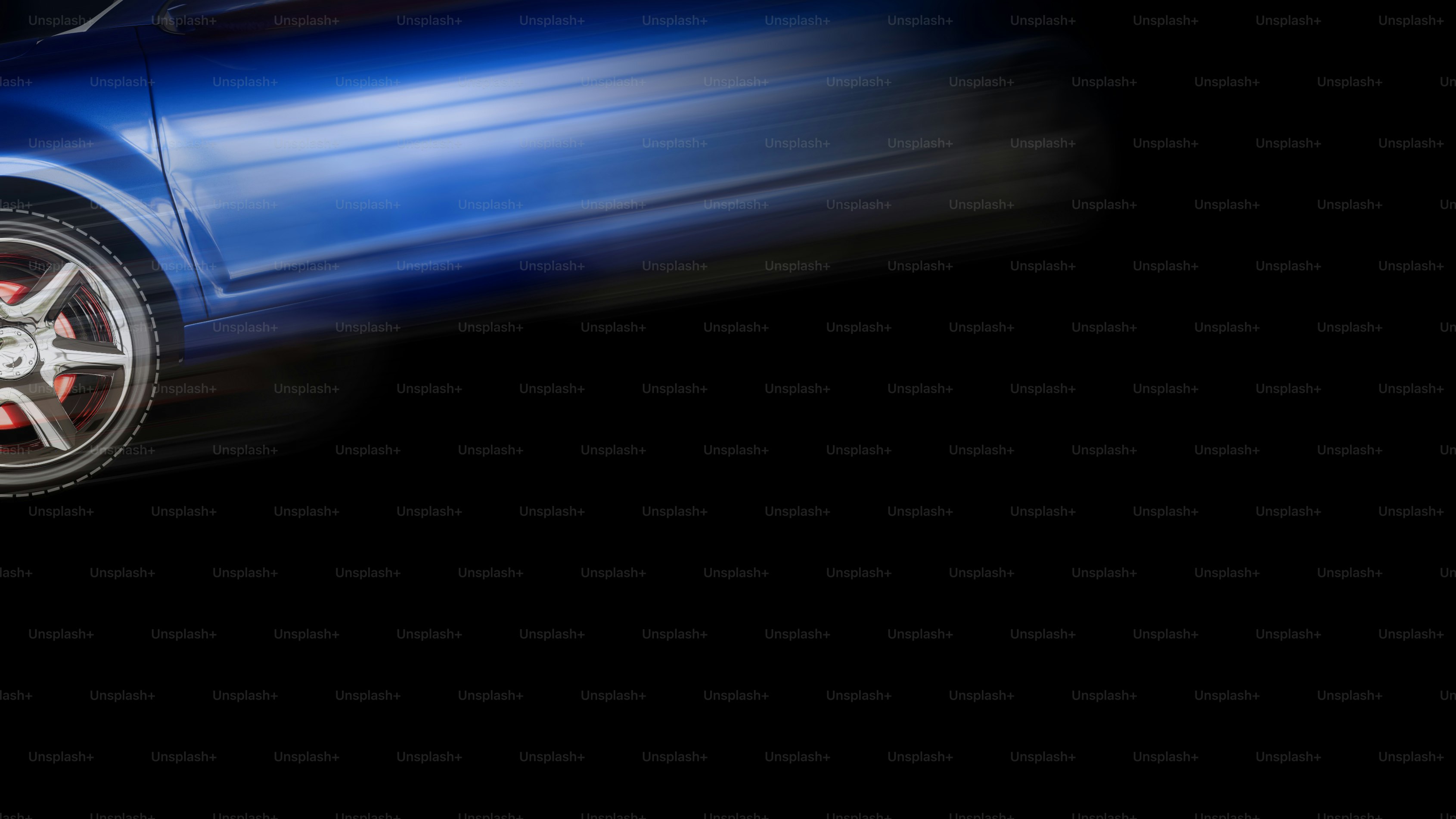 A blue car driving down a street at night