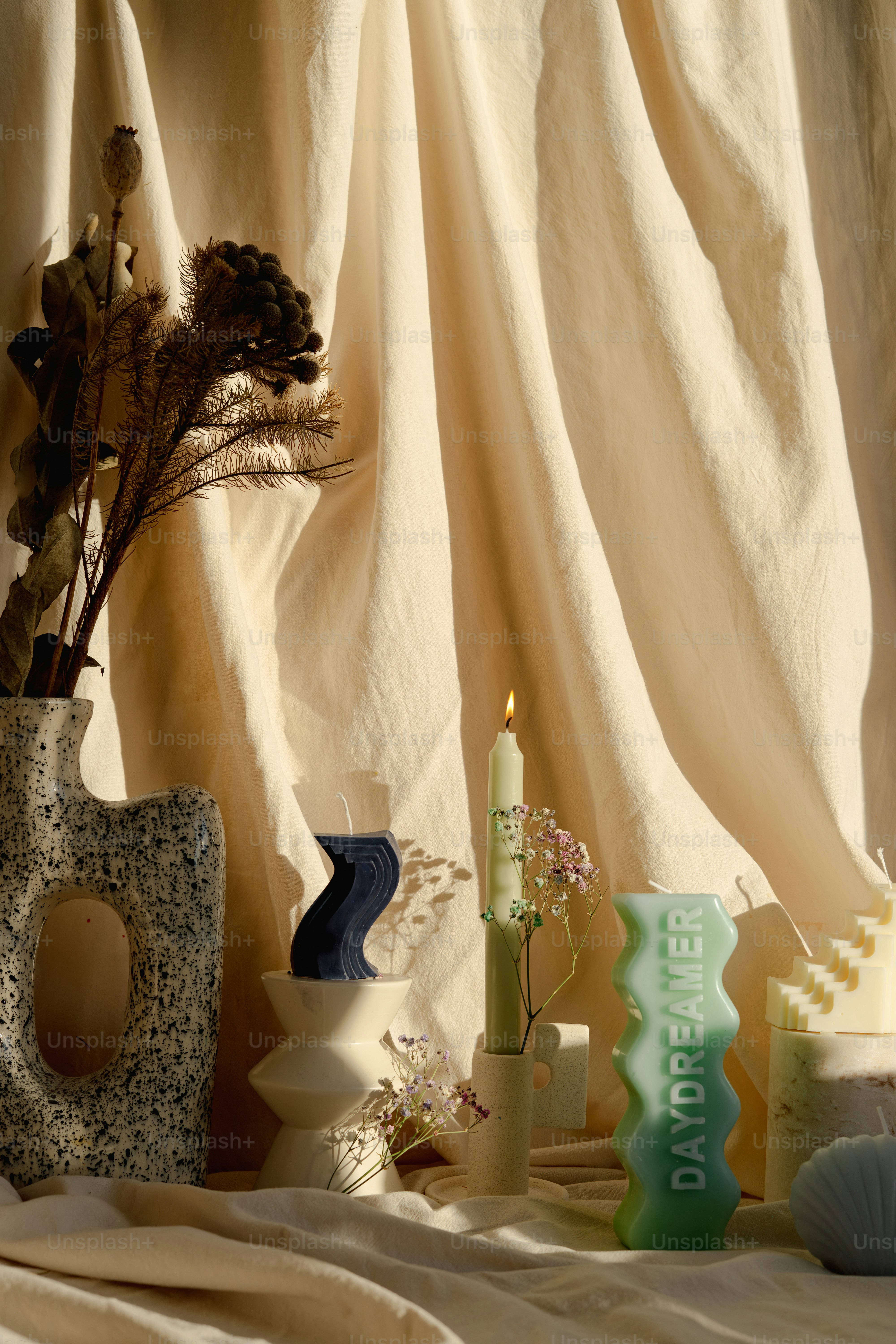 A table topped with vases filled with flowers and candles