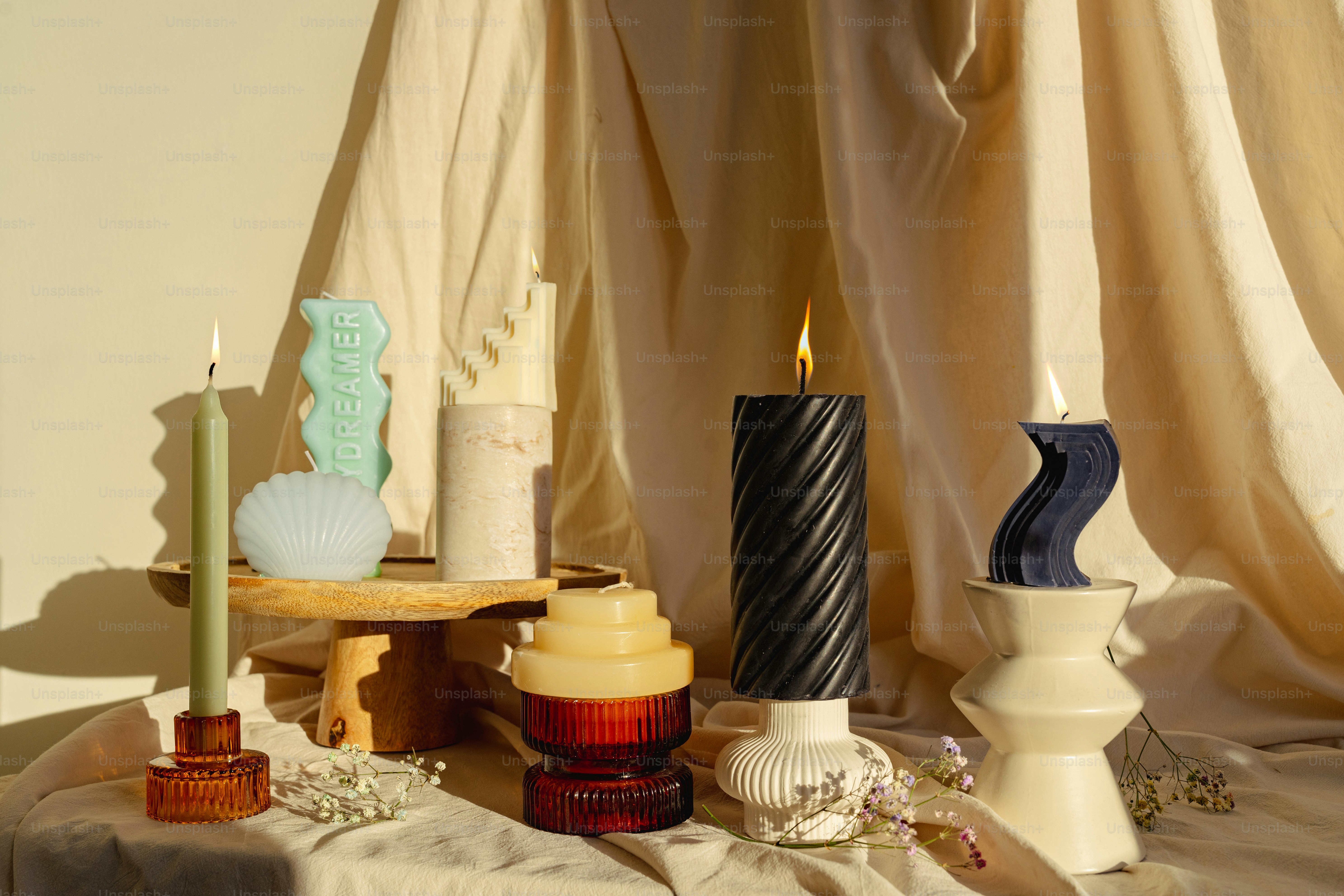 A table topped with candles next to a curtain