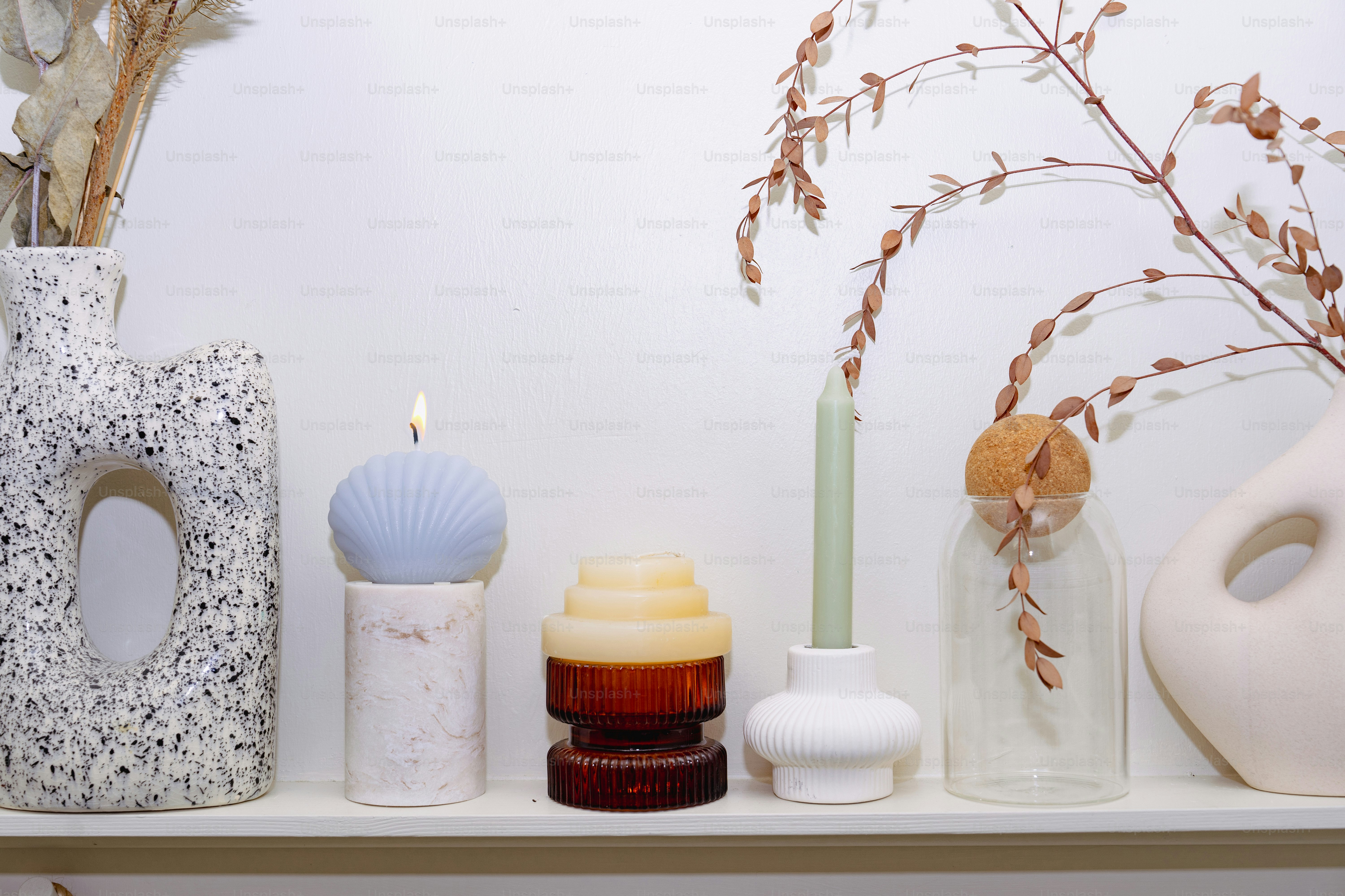 A shelf with vases and candles on it