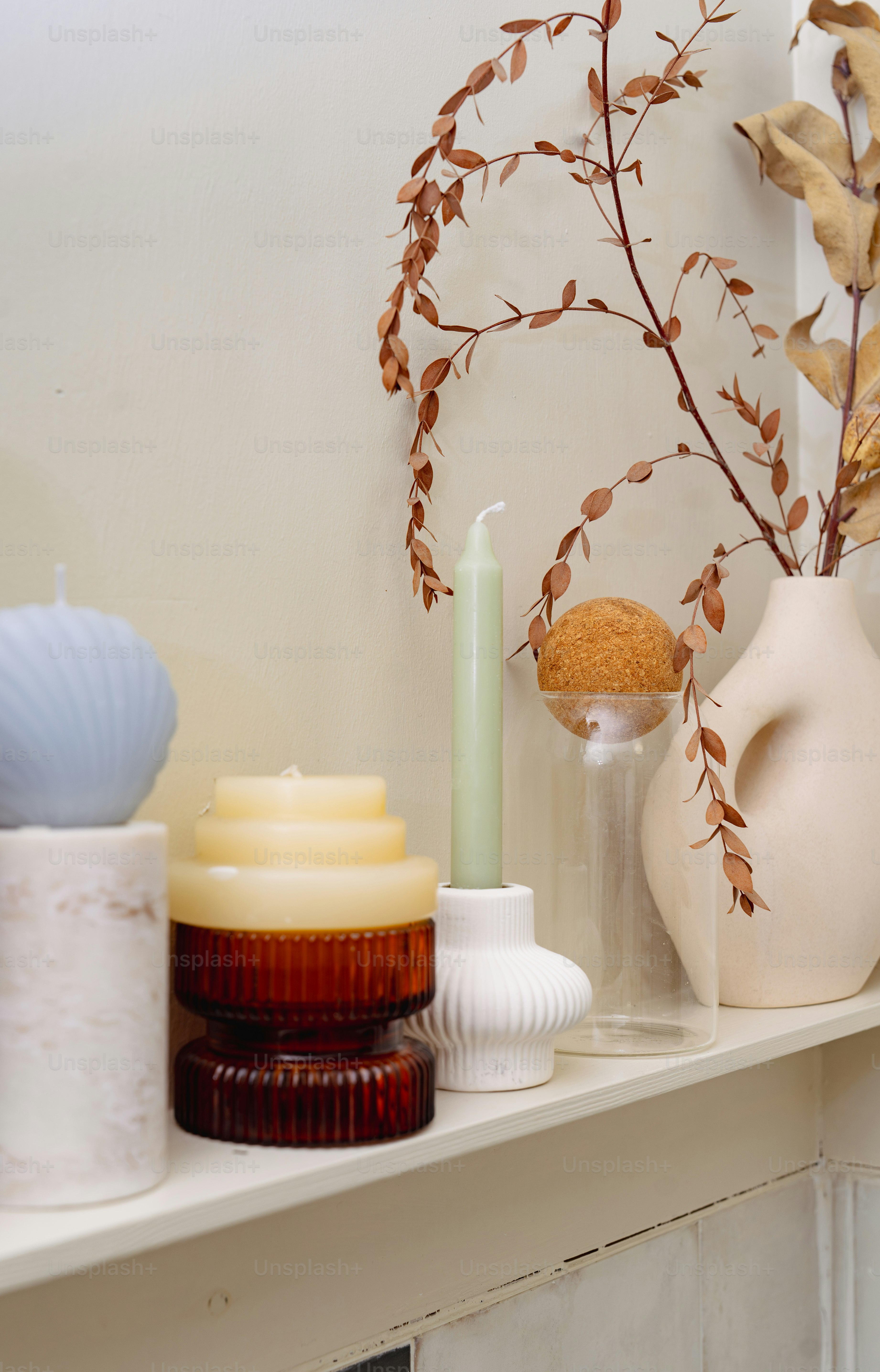 A shelf with vases and candles on it