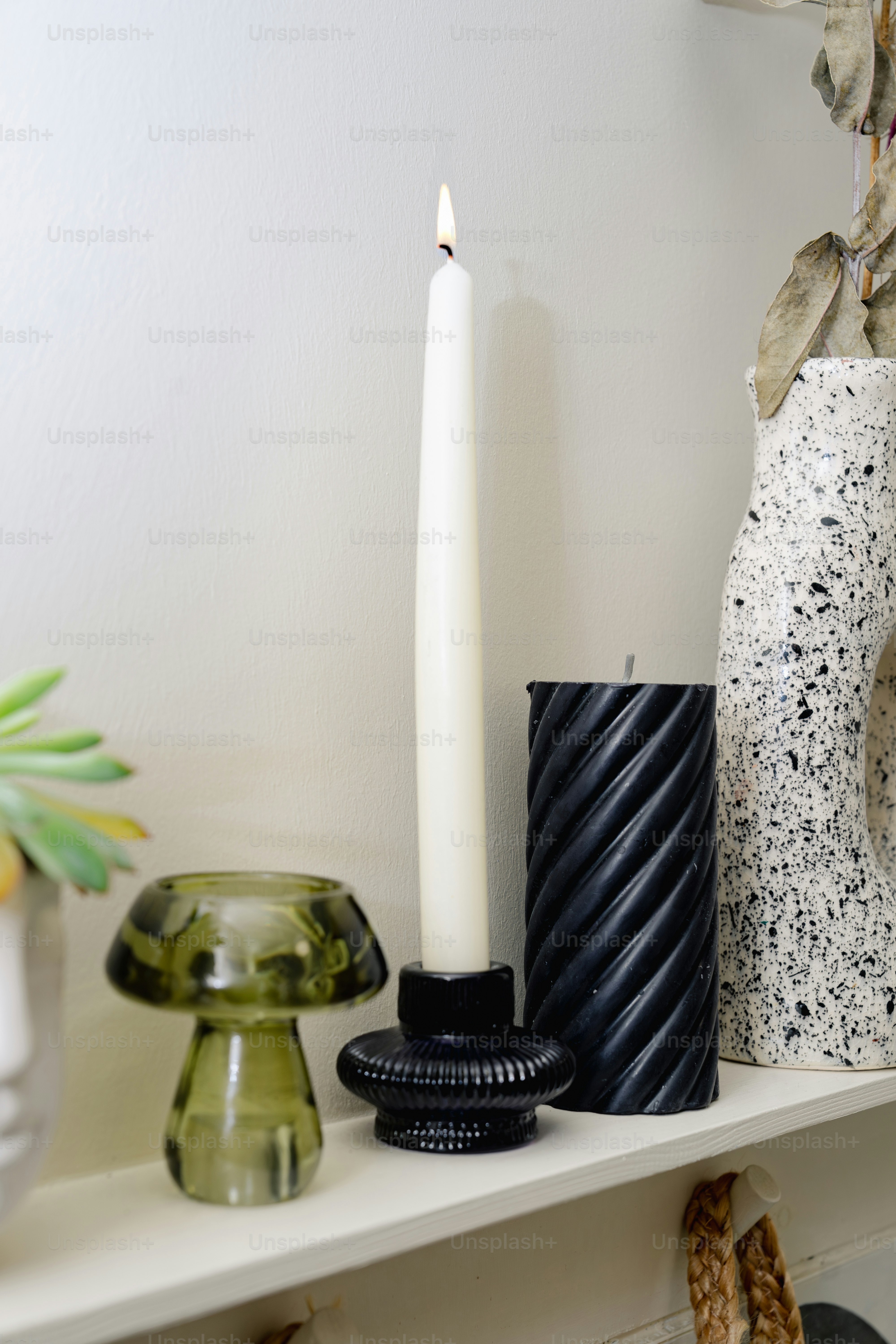 A shelf with candles, vases and other items on it