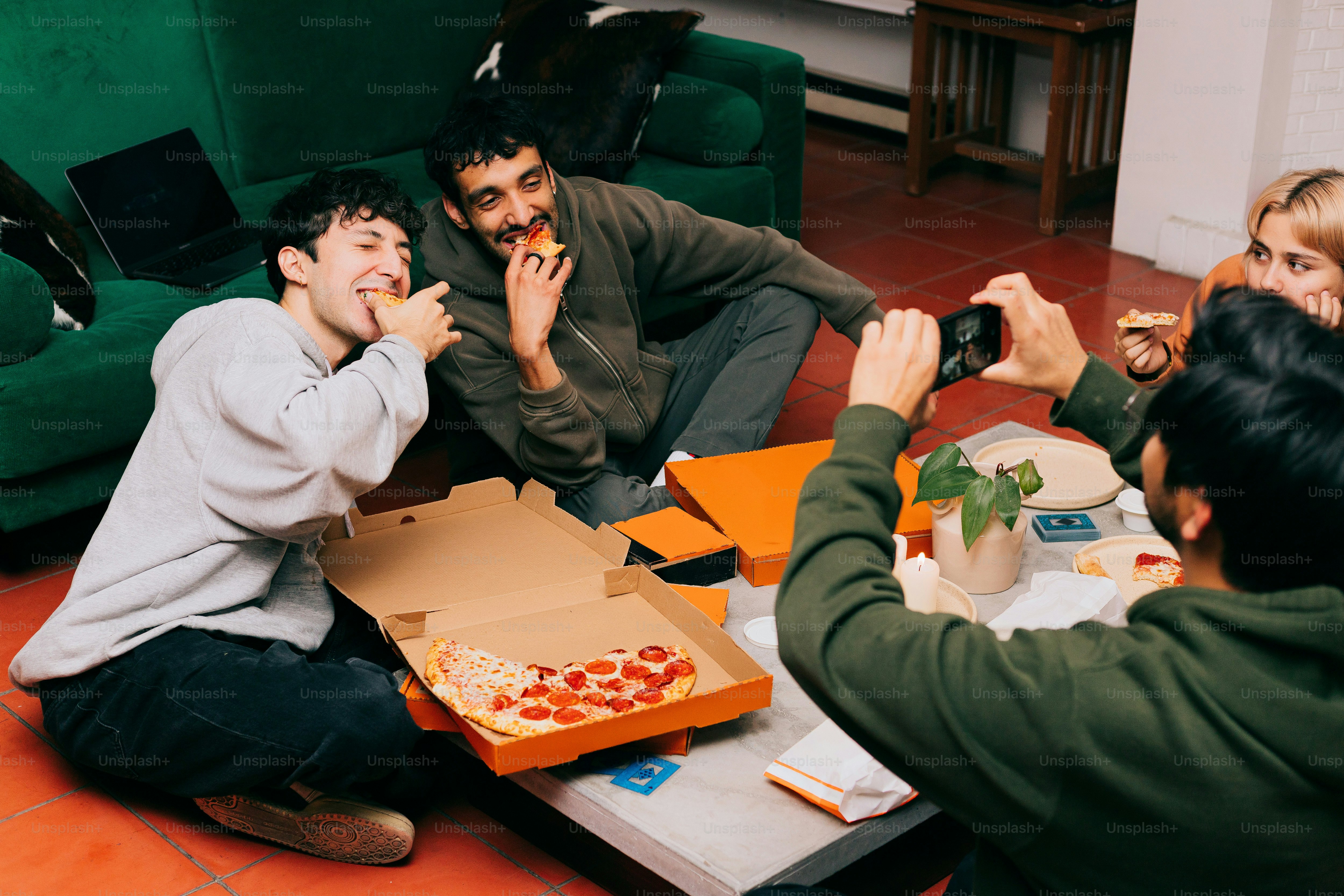 A group of people sitting around a table eating pizza