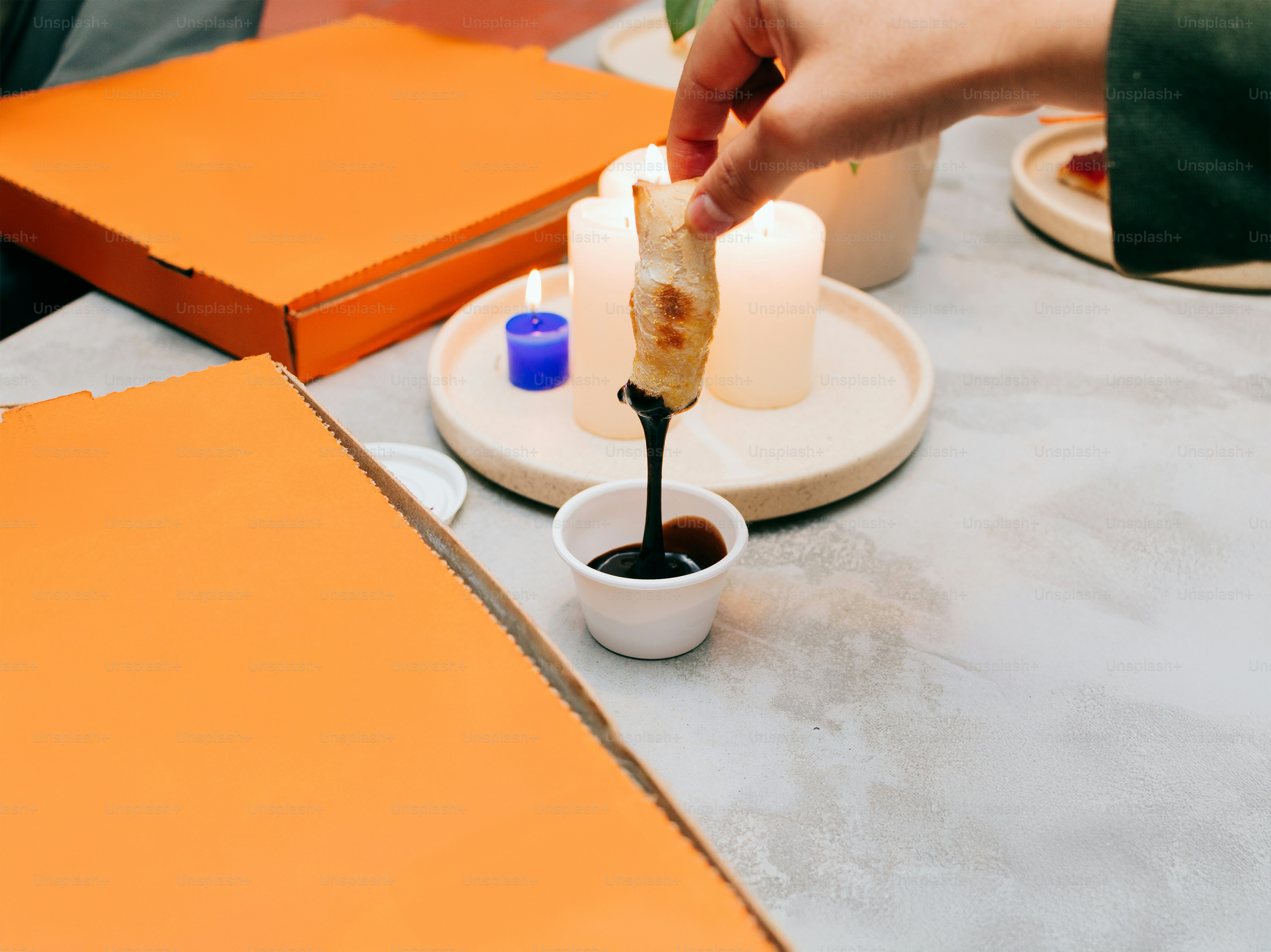 A person is dipping something into a small bowl
