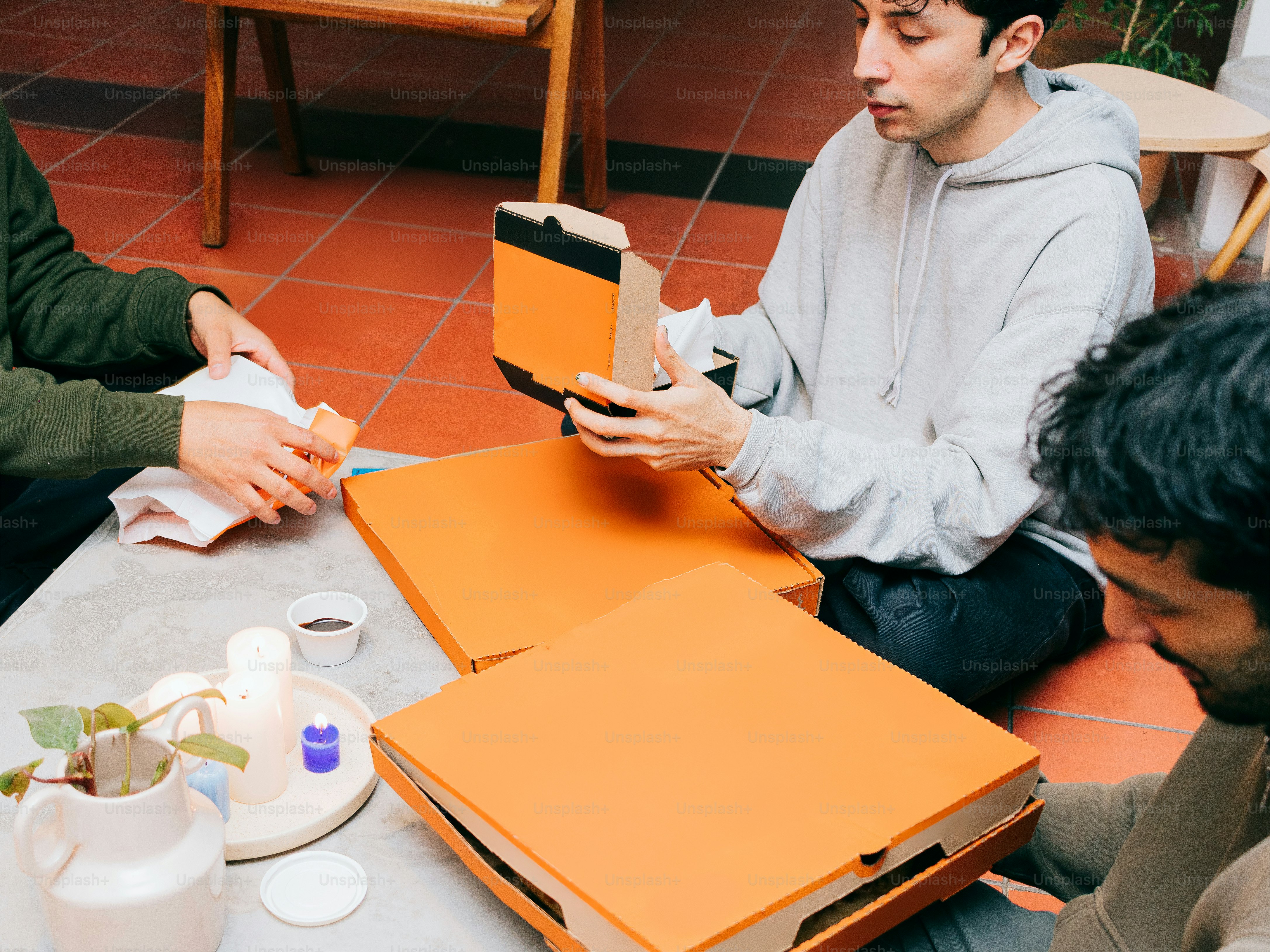 A group of men sitting around a table looking at a book