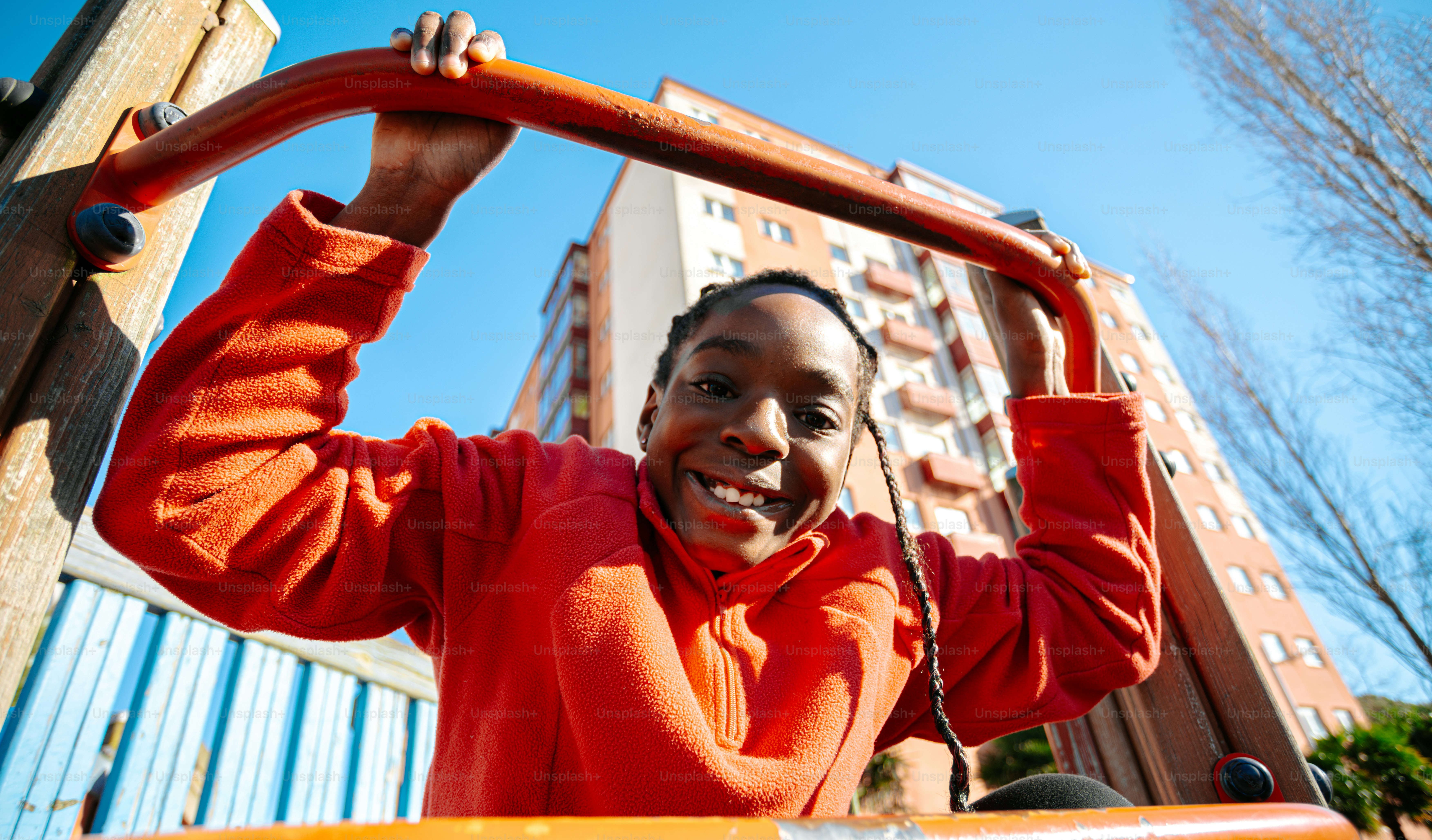 A woman in an orange sweatshirt is holding a bar