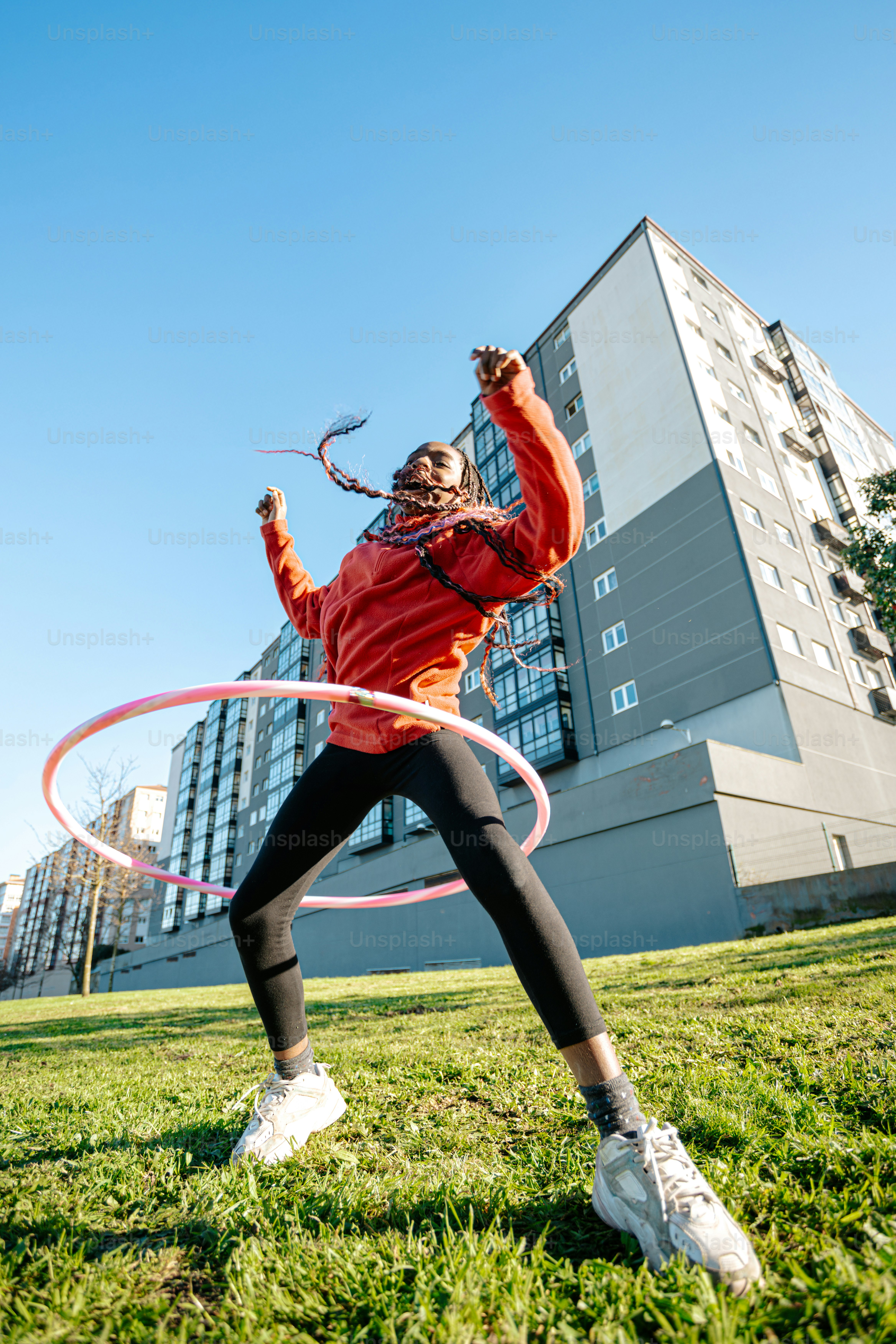A woman playing with a hula hoop in a park