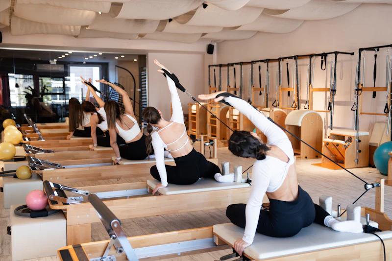 Group Pilates reformer class with multiple participants