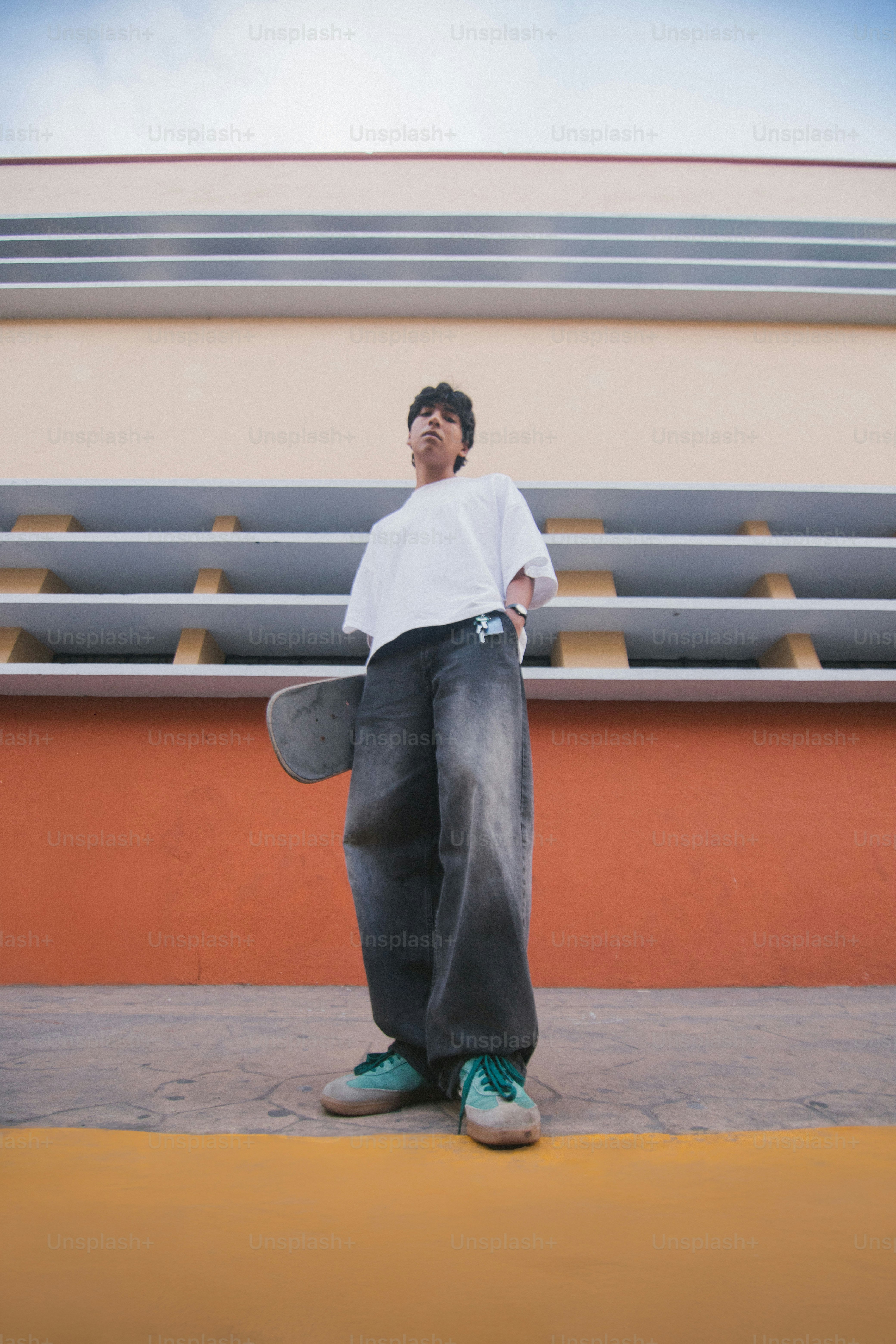 A man standing in front of a bleachers holding a skateboard