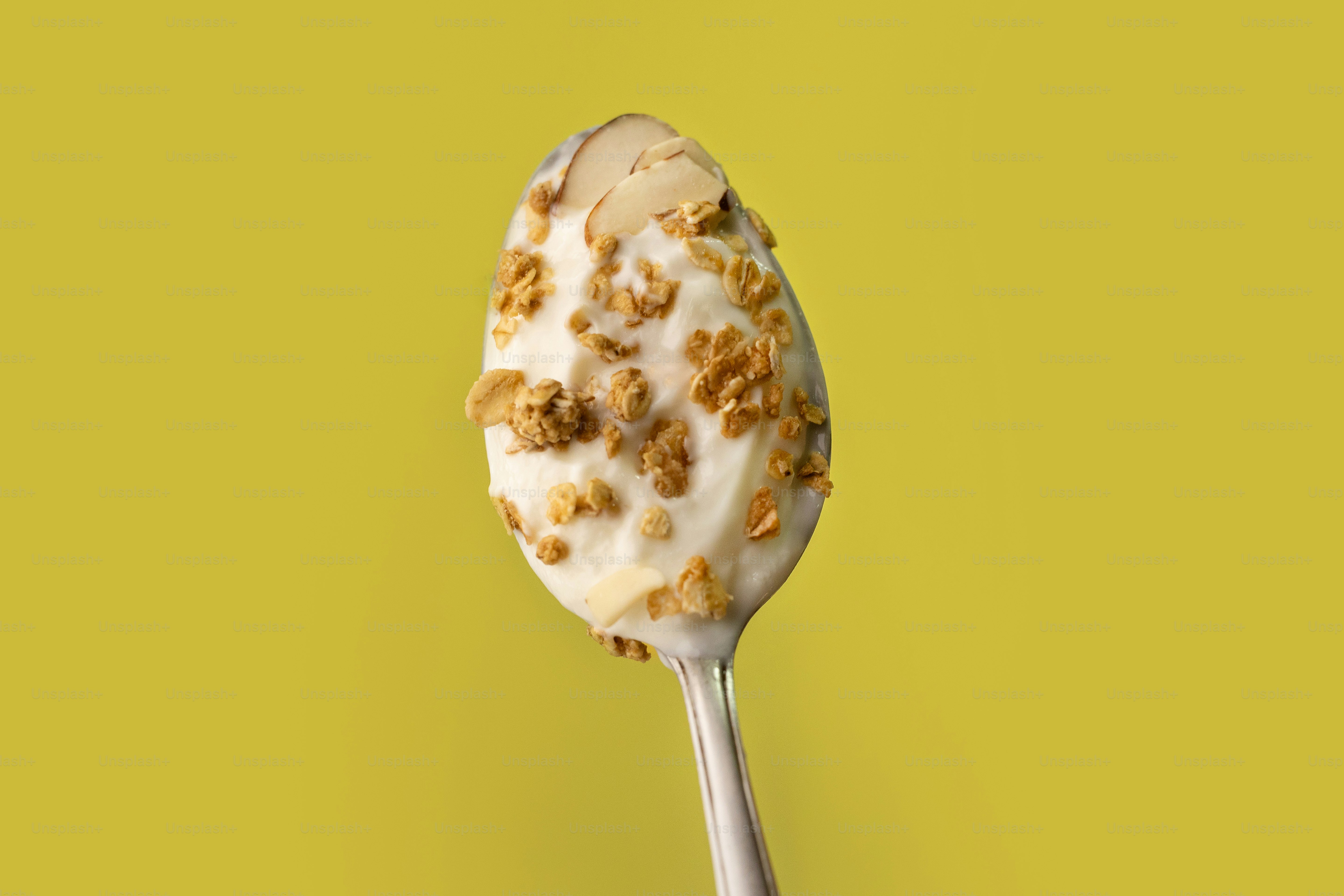 A spoon with a dessert on it on a yellow background