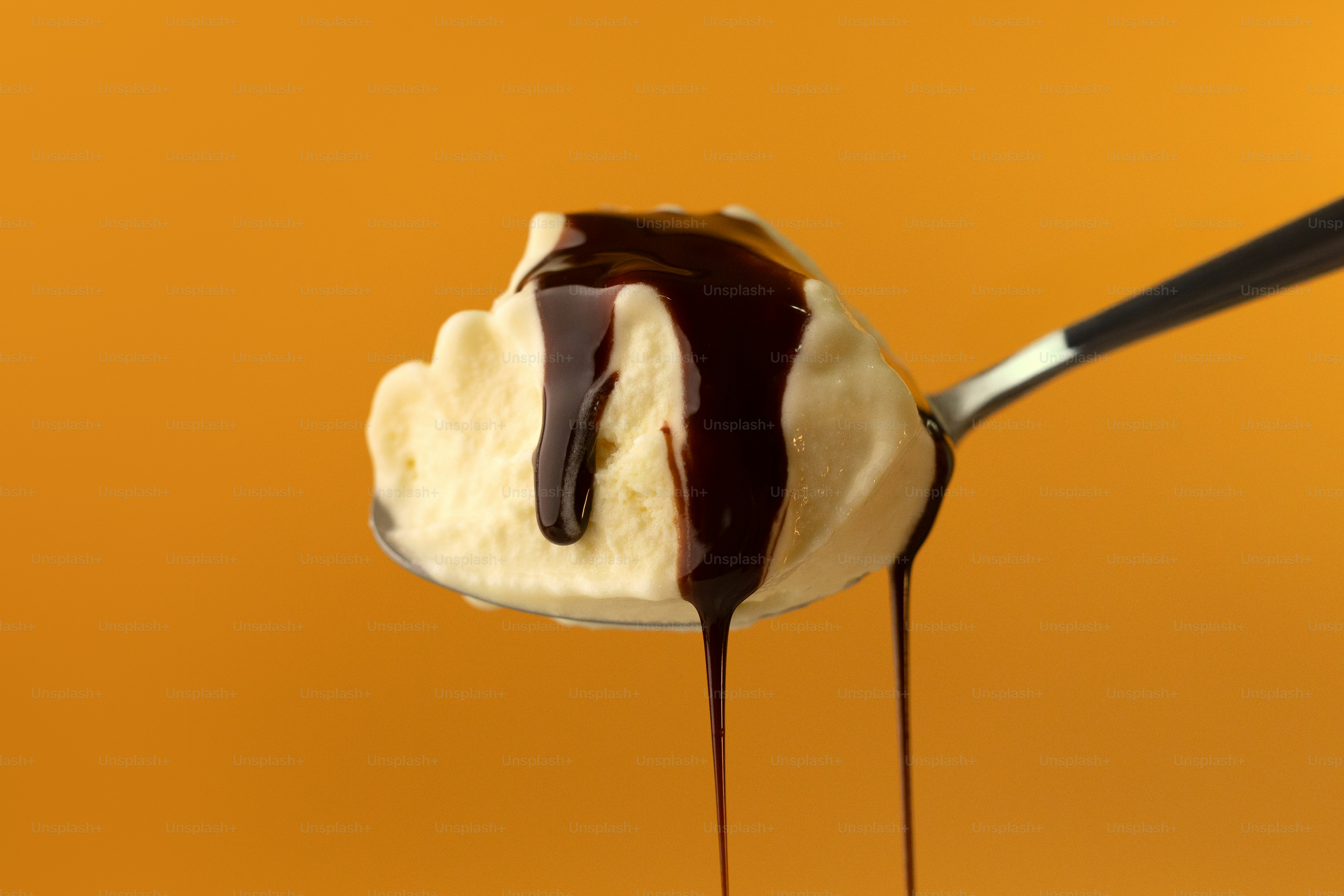 A spoon full of ice cream and chocolate sauce