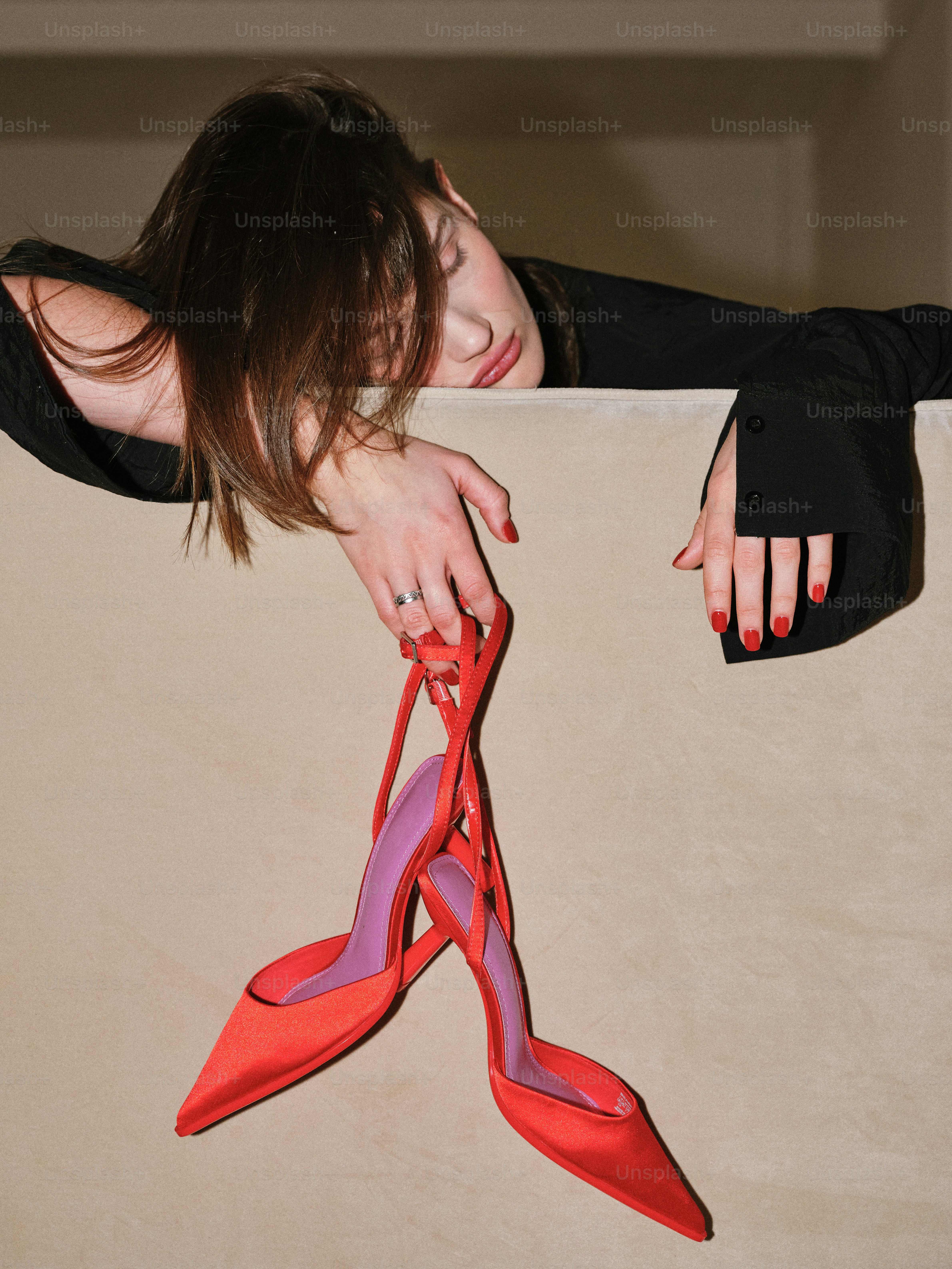 A woman holding onto a pair of red shoes