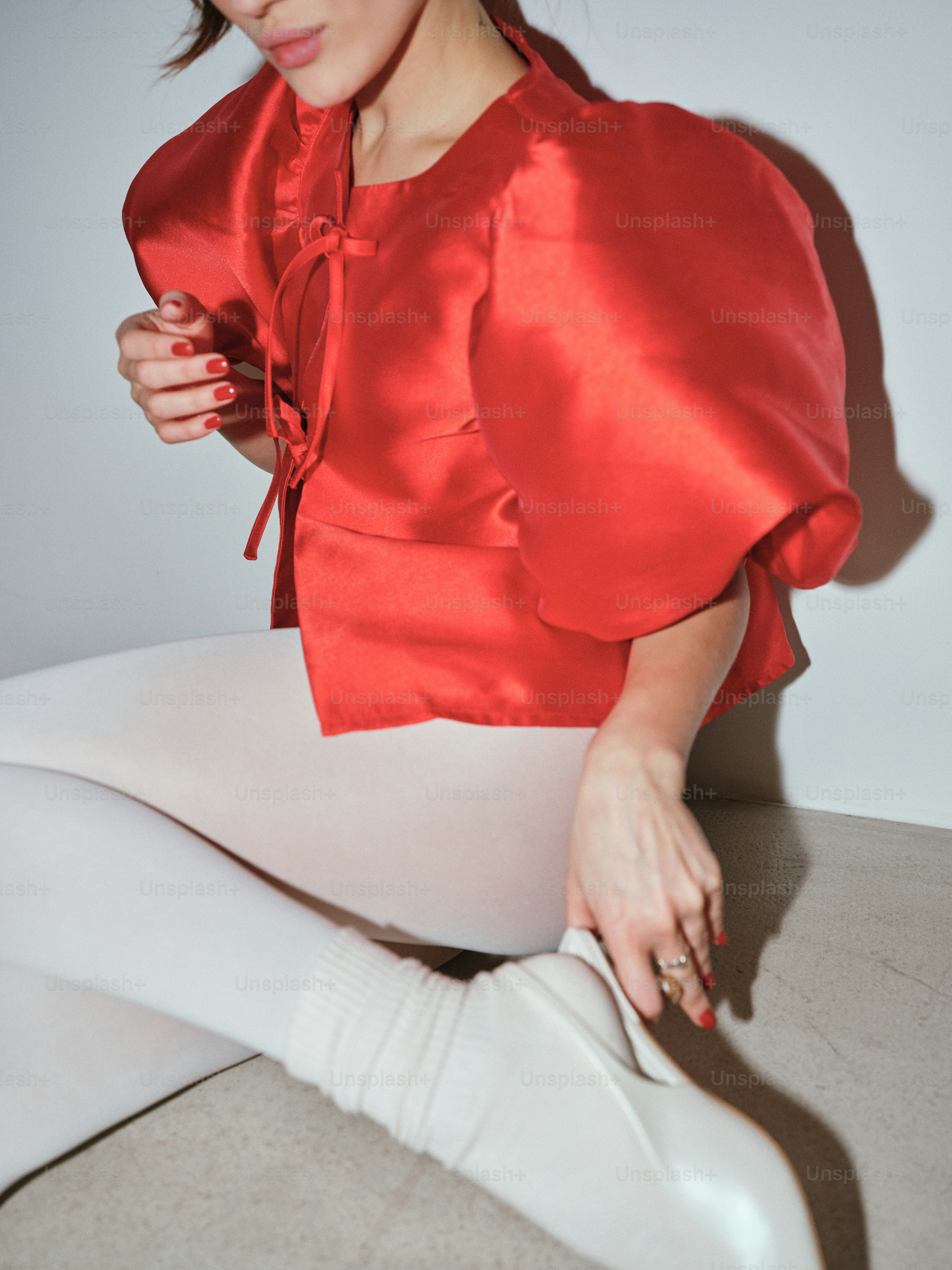 A woman in white pants and a red top