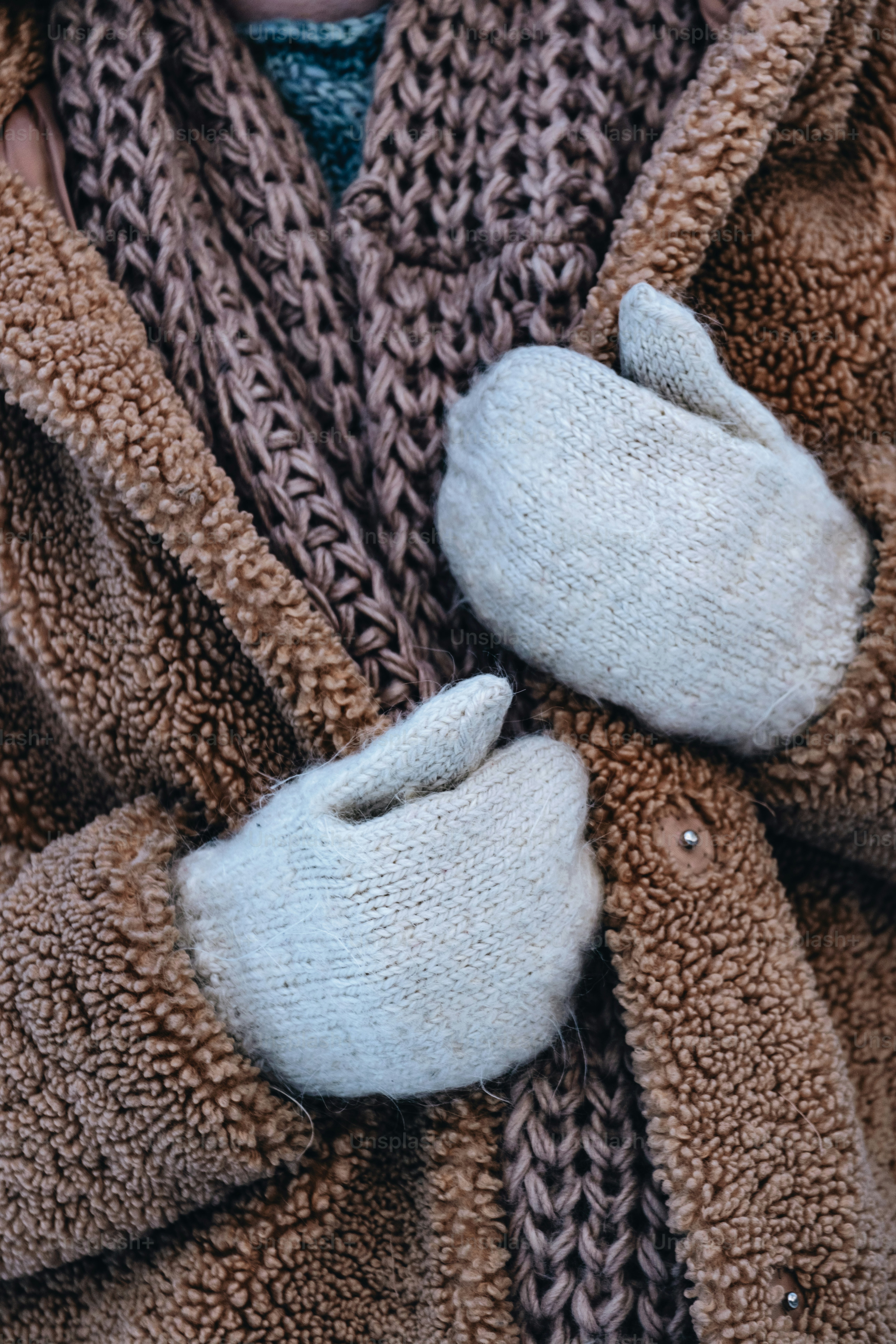 Eine Frau in einem braunen Mantel und weißen Handschuhen