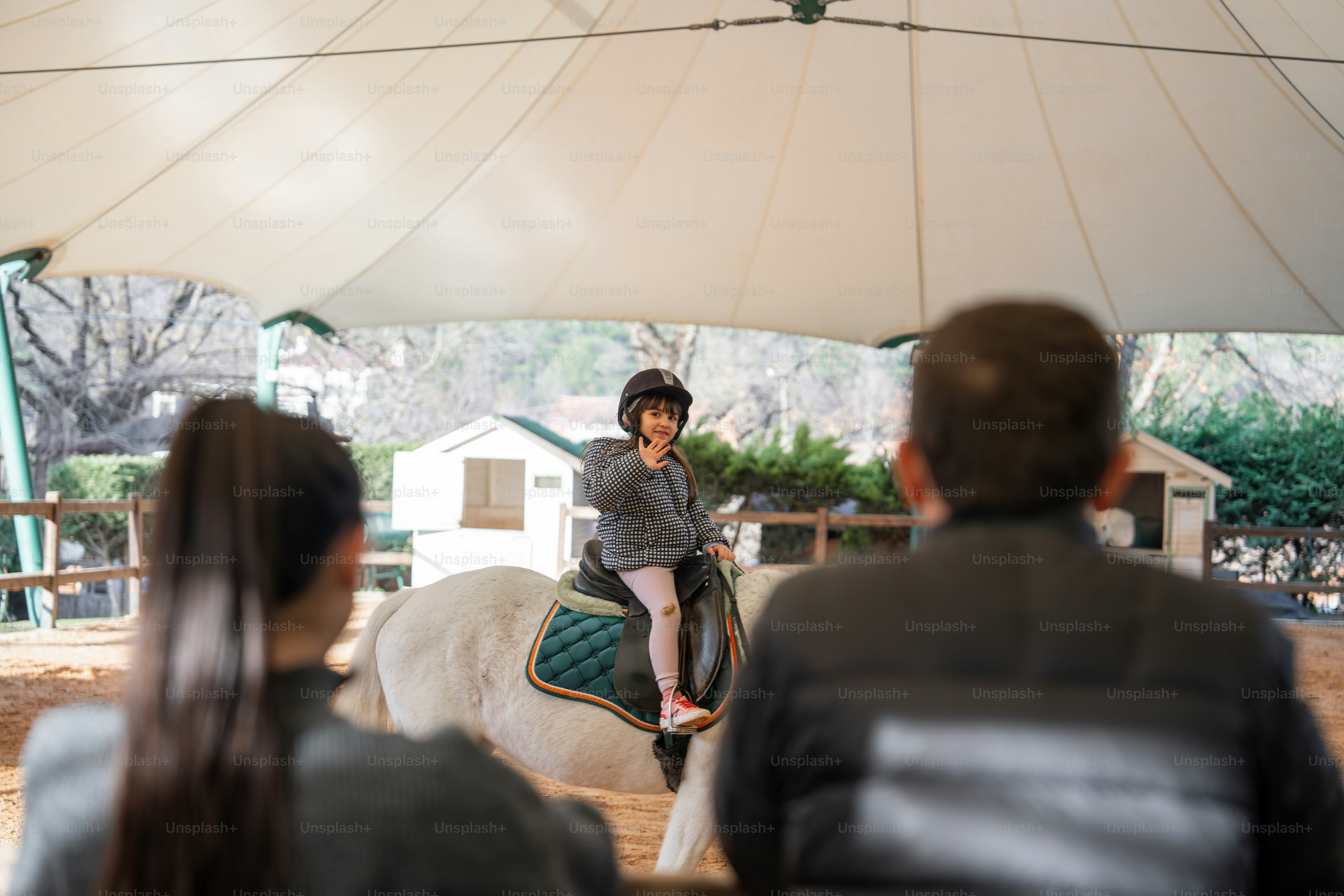 A woman riding on the back of a white horse