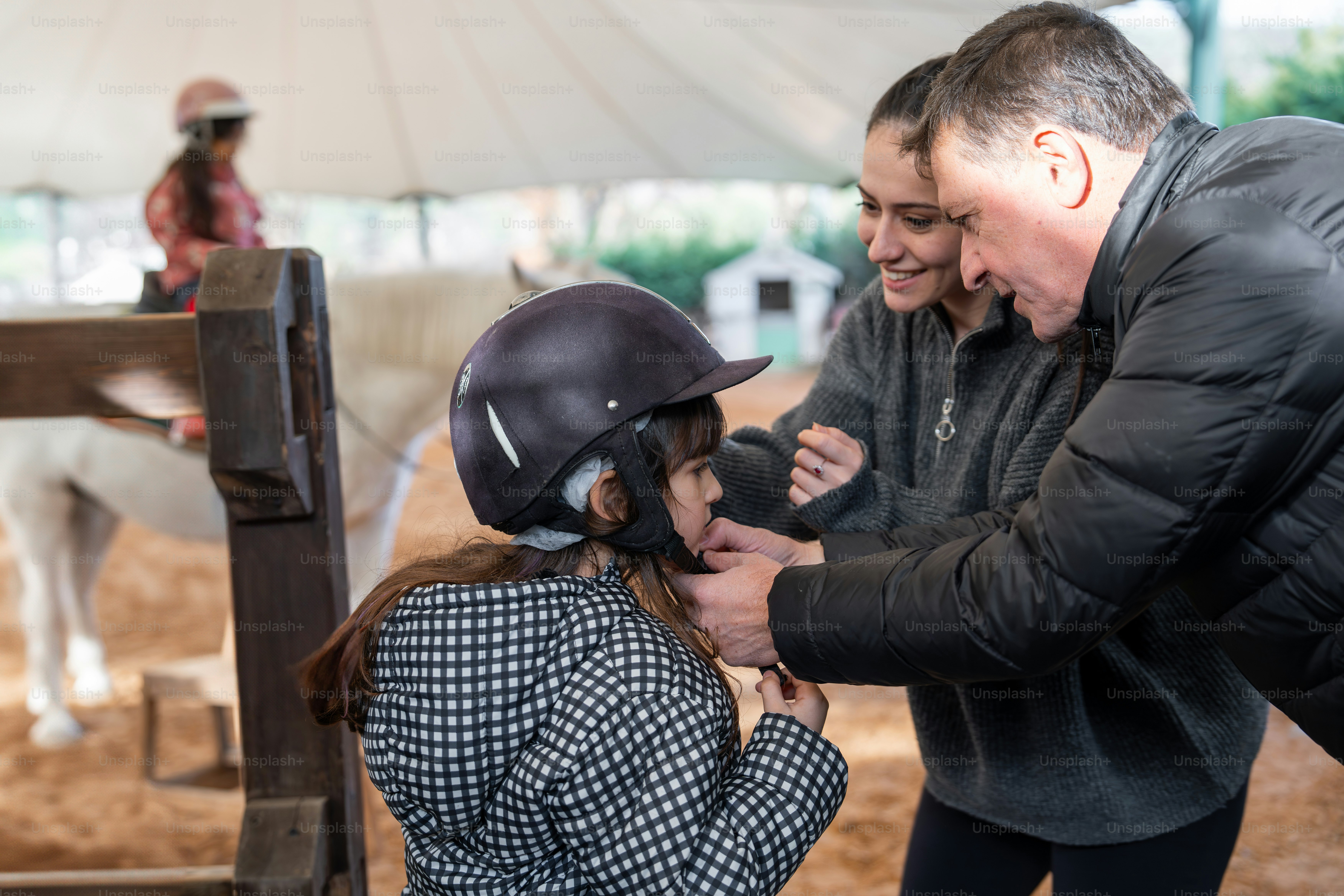 A man is helping a woman put on a helmet