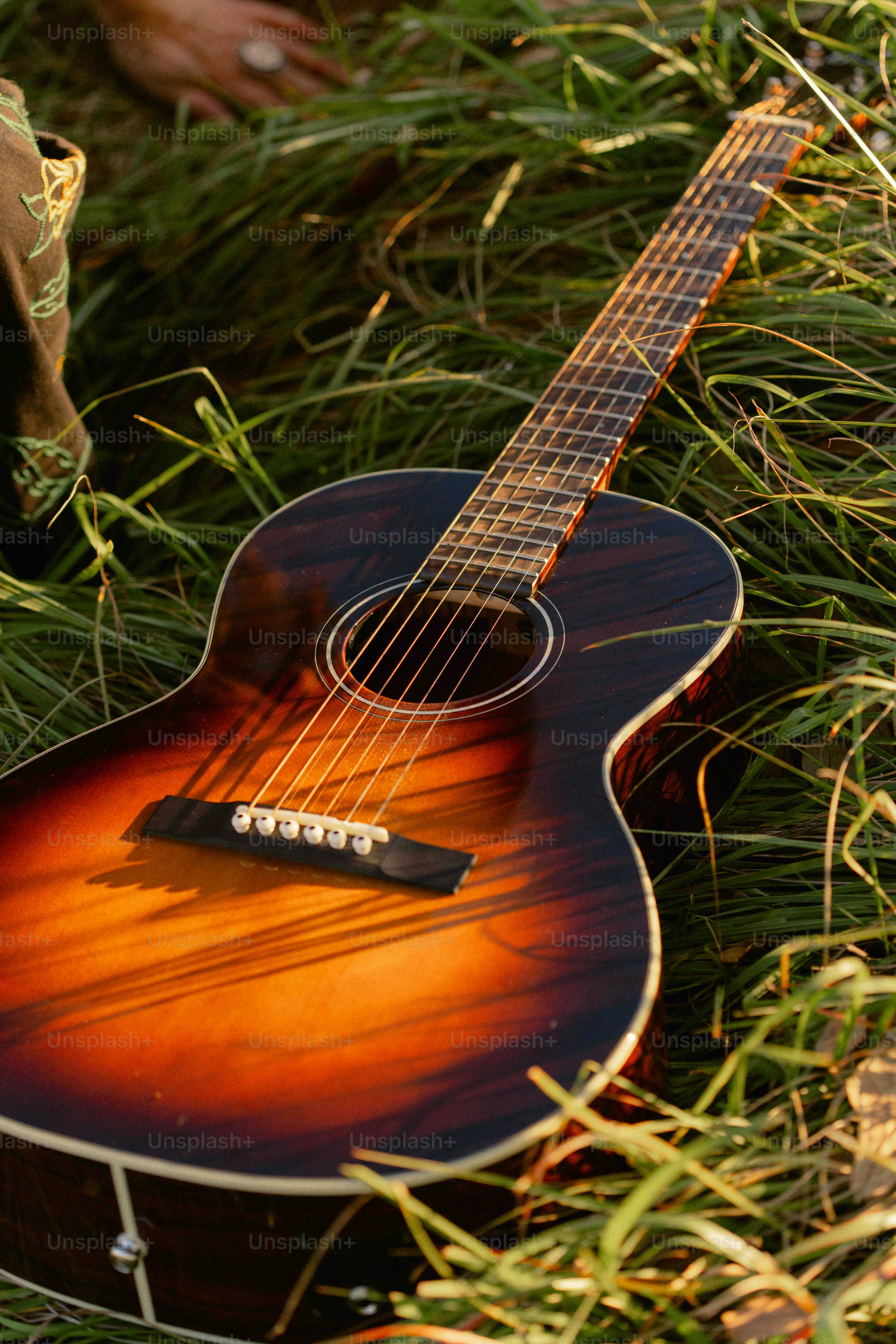 Uma guitarra deitada no chão na grama