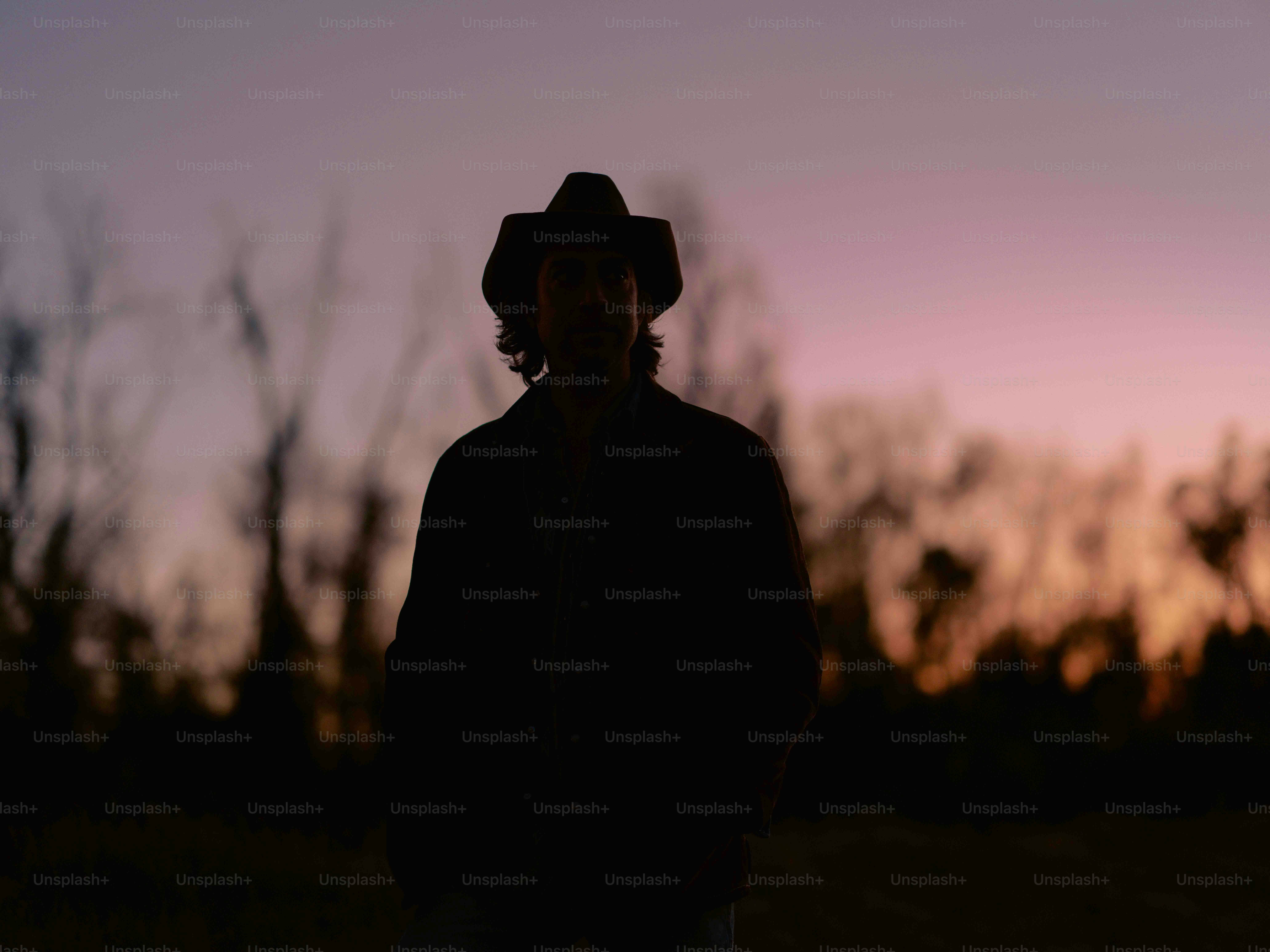 A silhouette of a man wearing a cowboy hat