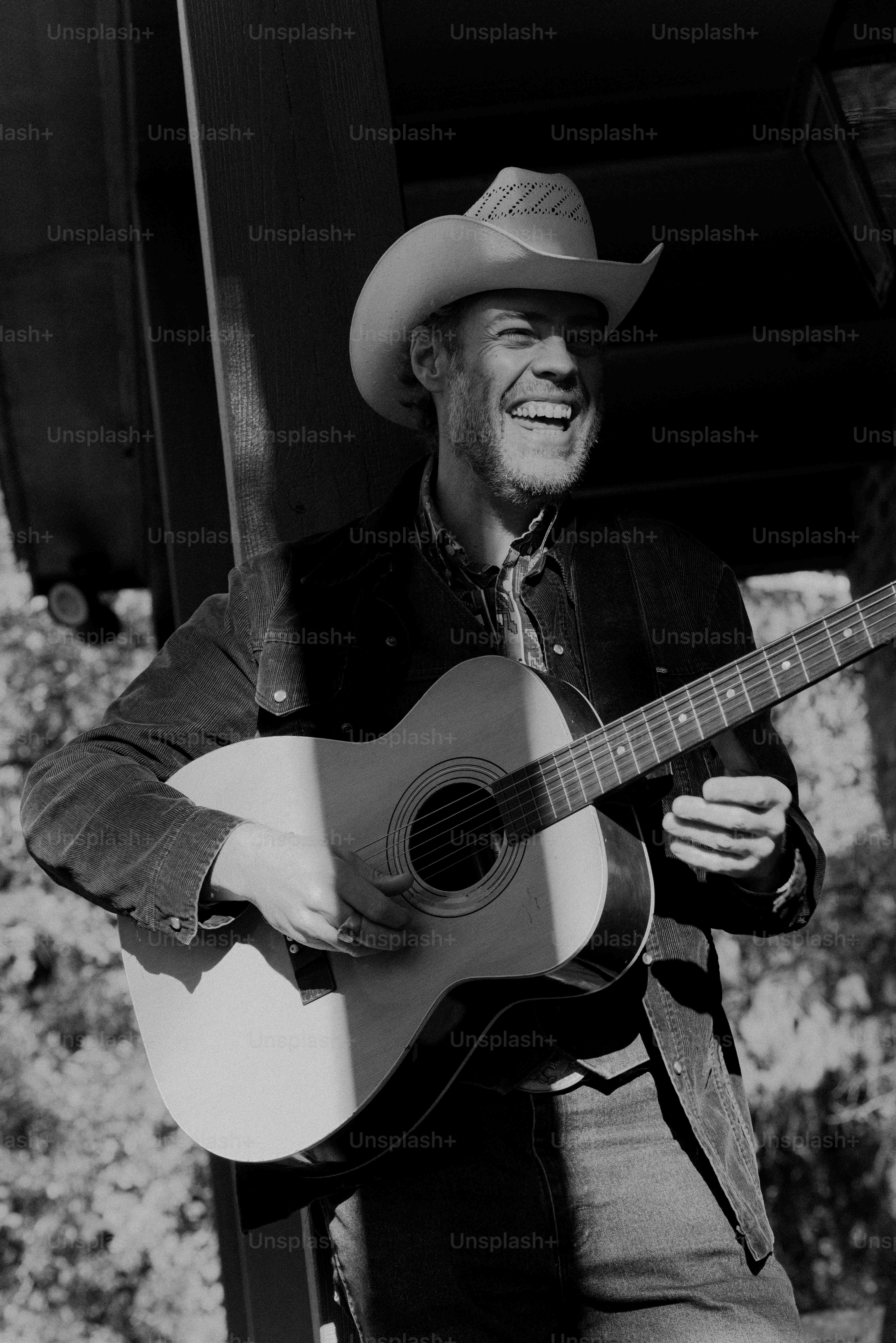Un homme avec un chapeau de cow-boy jouant de la guitare