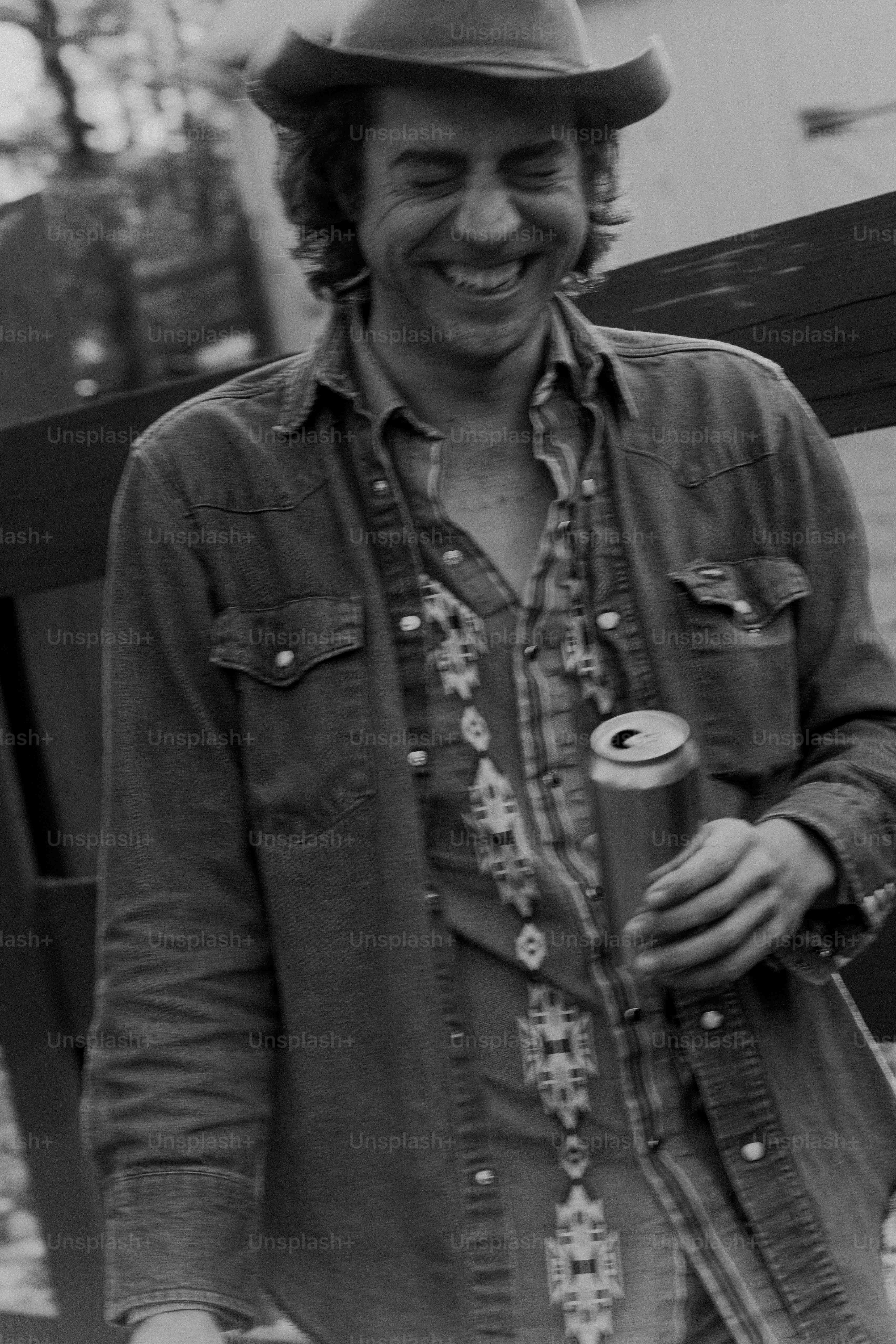 A man standing next to a plane holding a can of beer