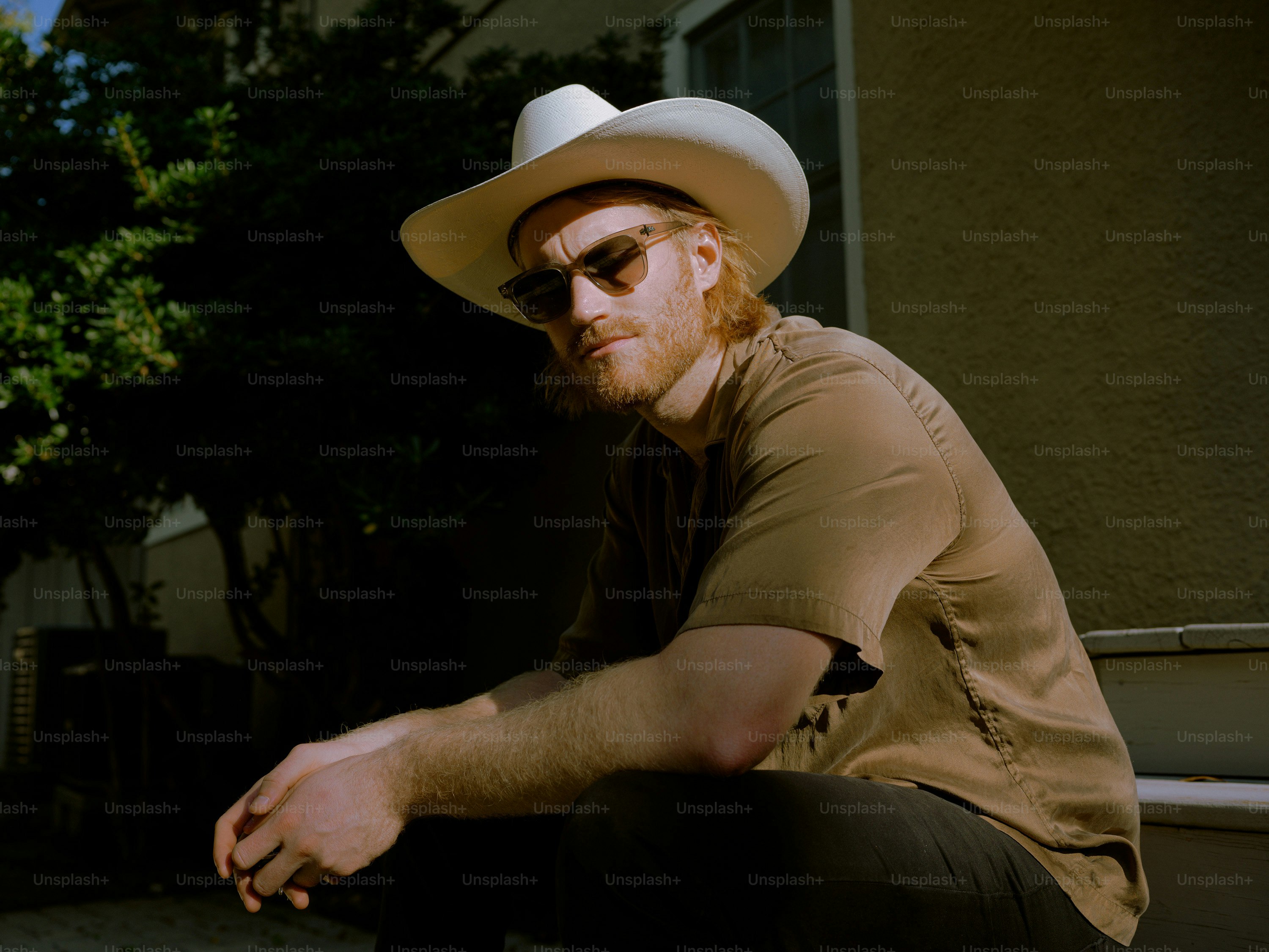 A man in a cowboy hat sitting on a bench