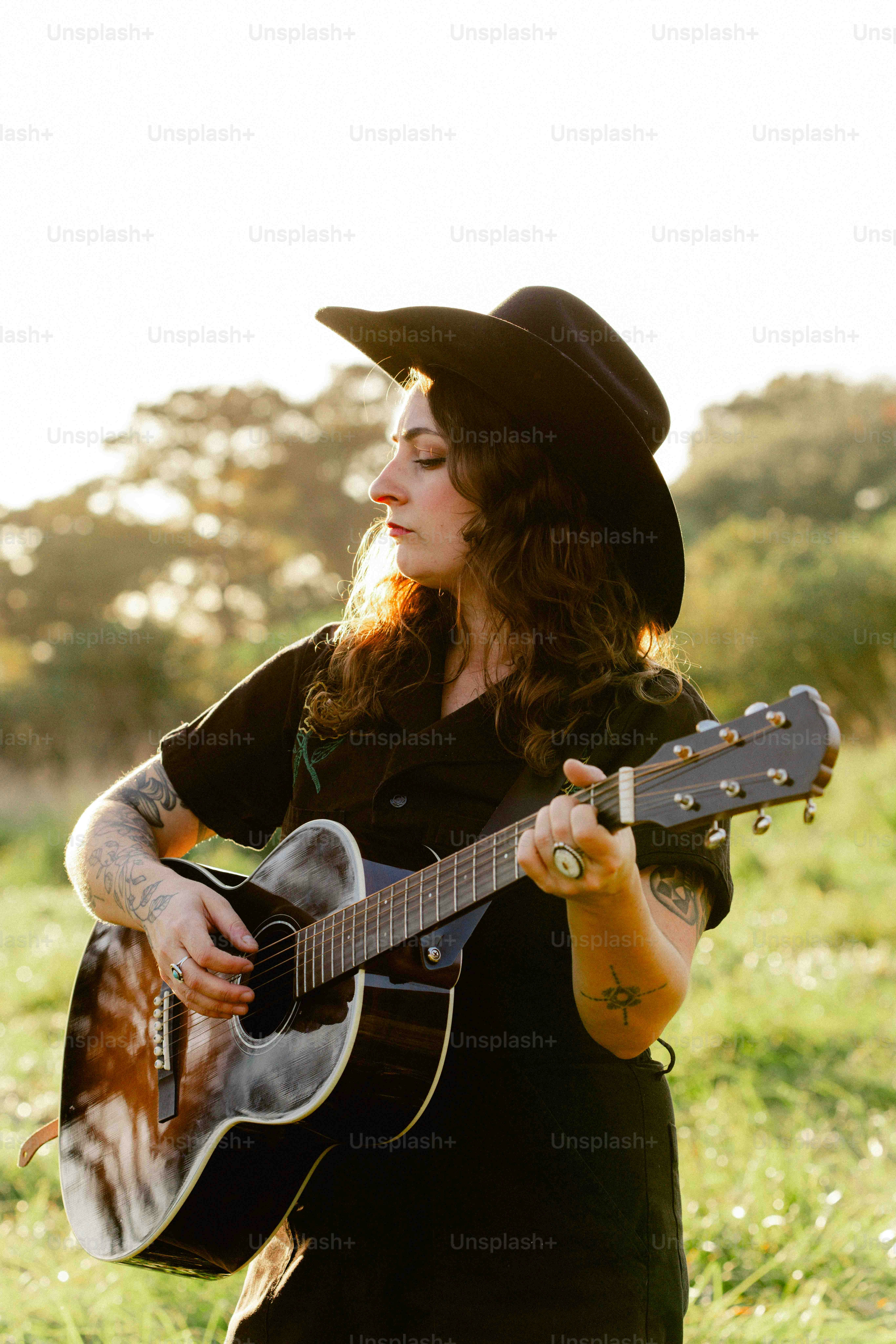 Seorang wanita dengan topi koboi bermain gitar