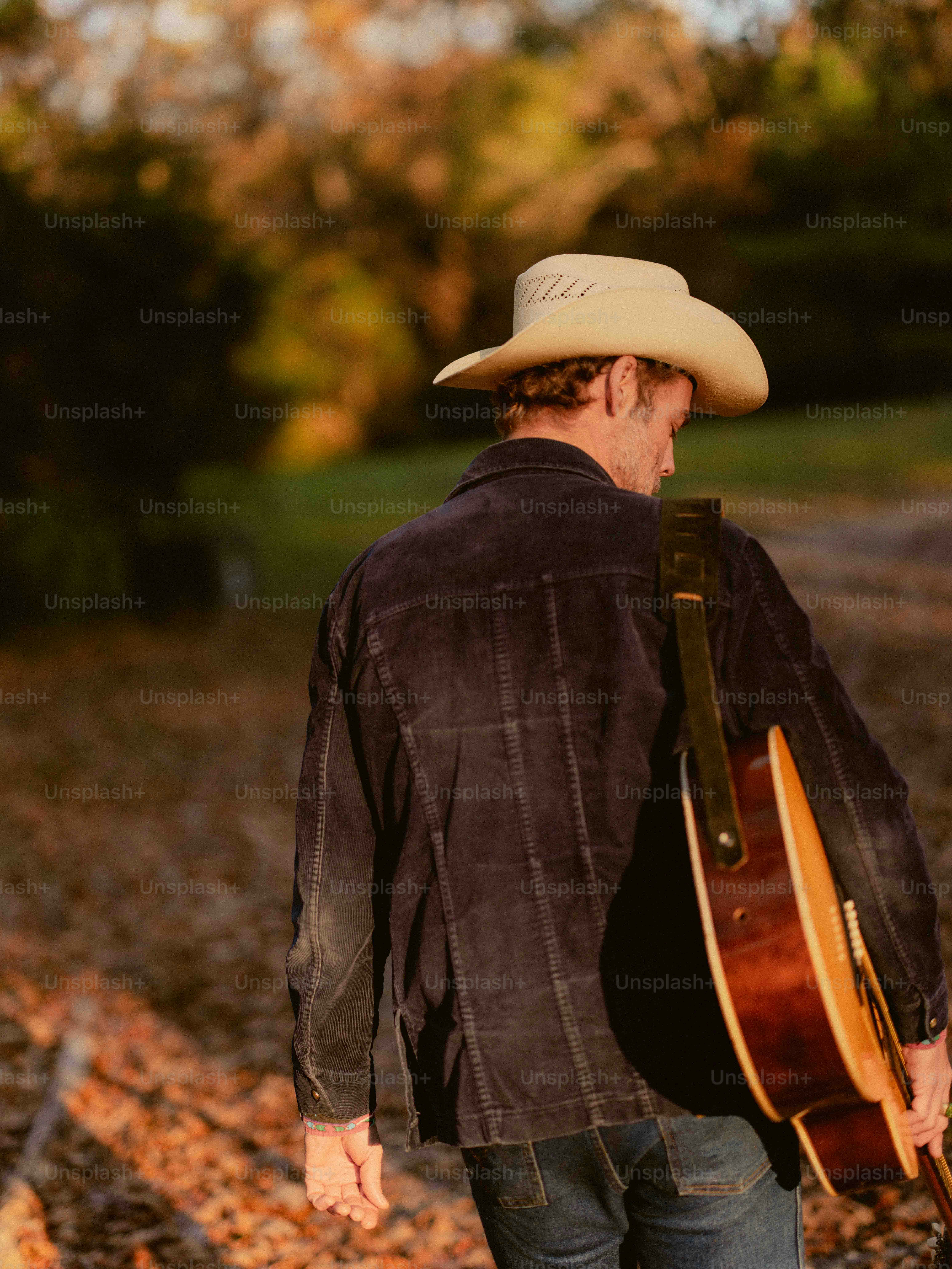 Un homme avec un chapeau de cow-boy tenant une guitare