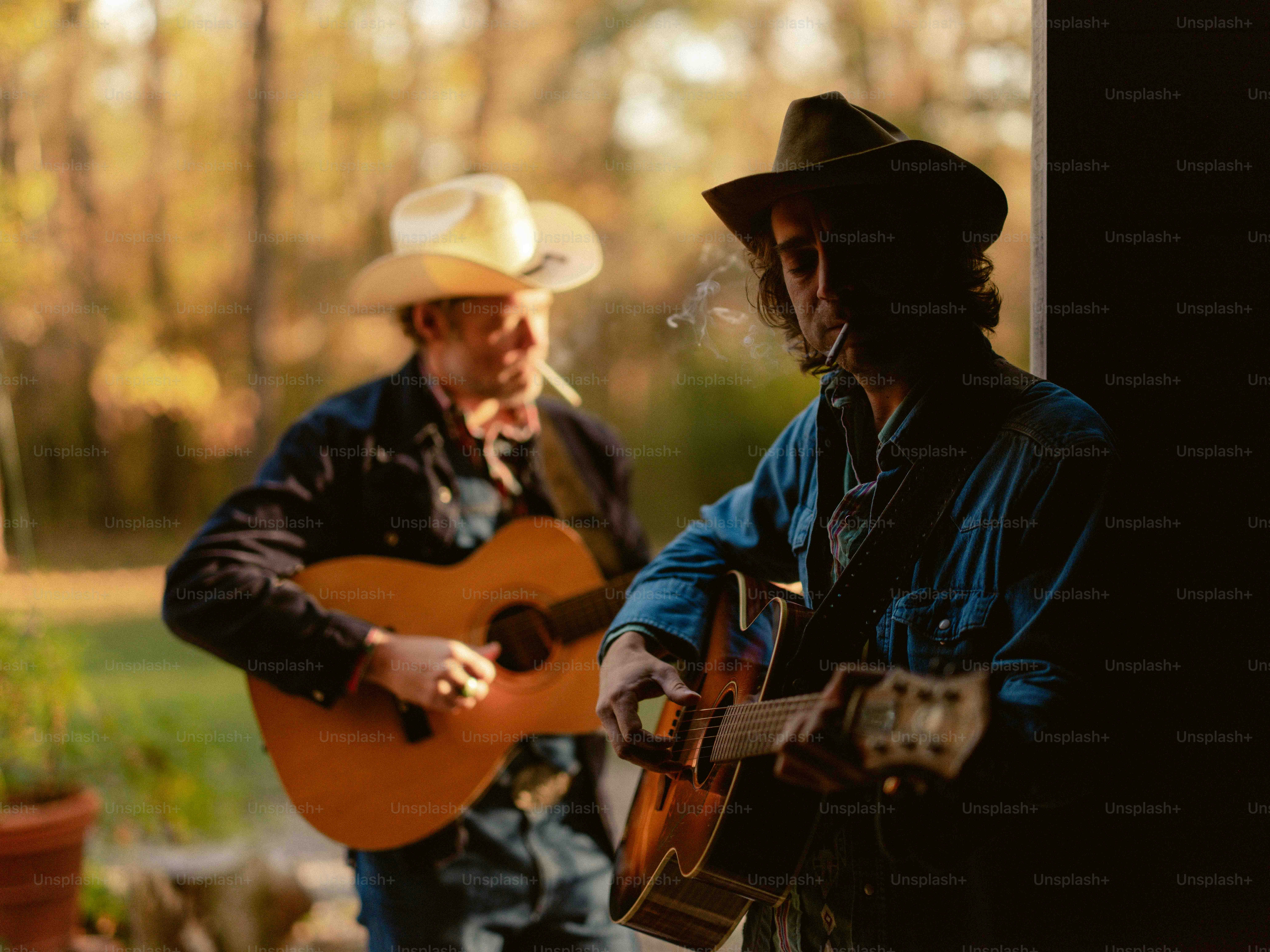 Un homme jouant de la guitare à côté d’un homme avec un chapeau de cow-boy