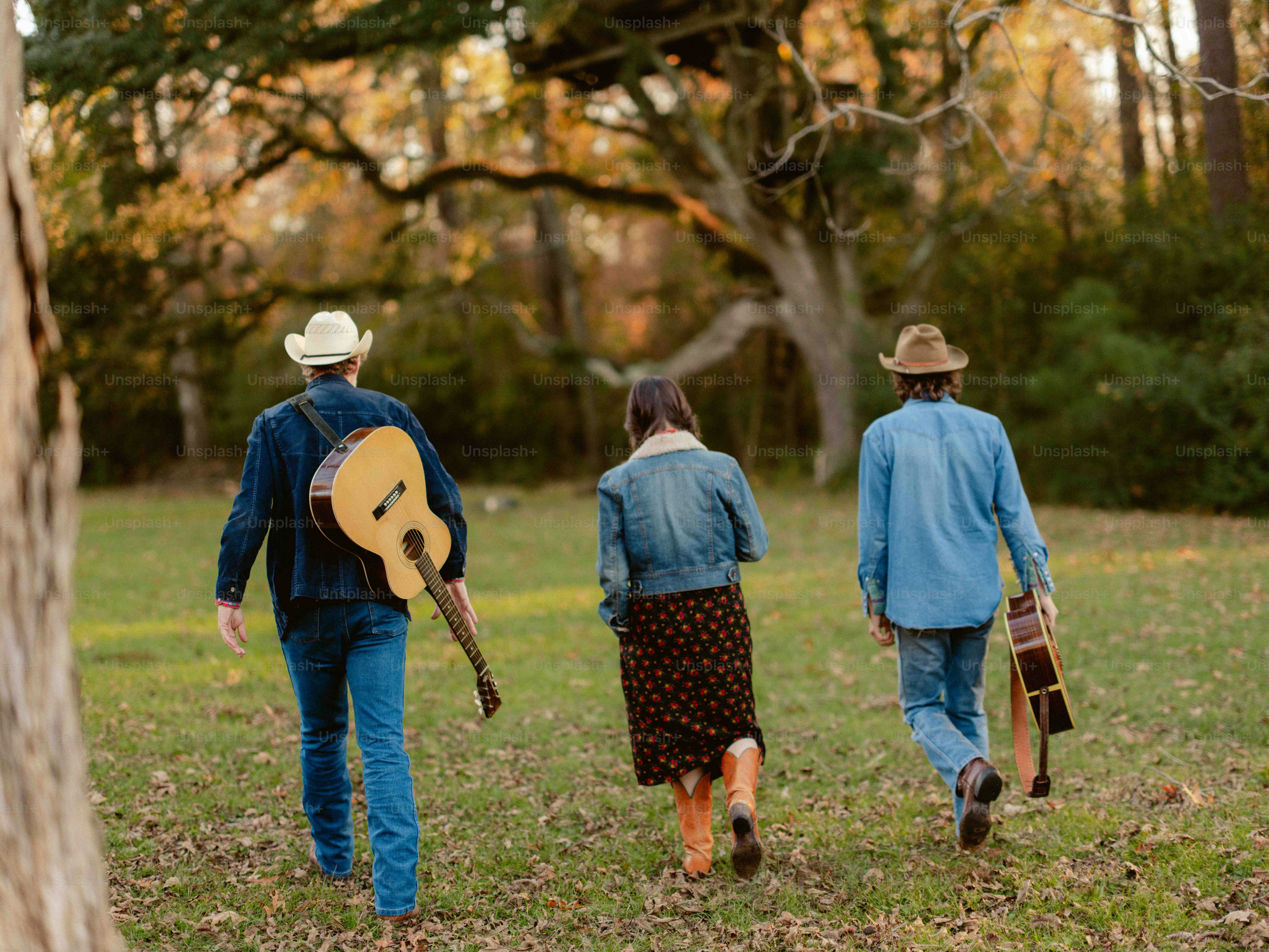 Un grupo de personas caminando por un campo con una guitarra