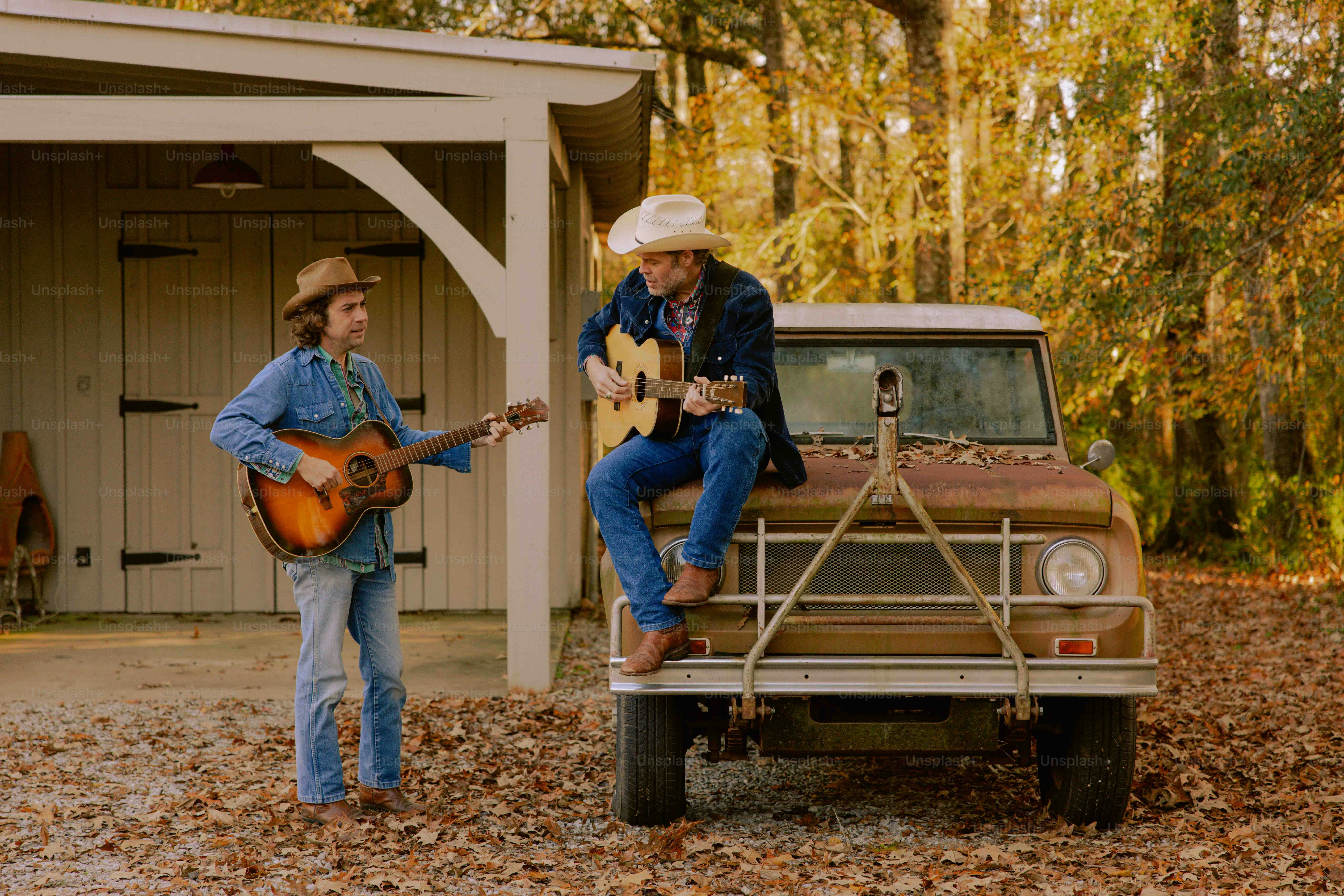 A man playing a guitar next to a truck
