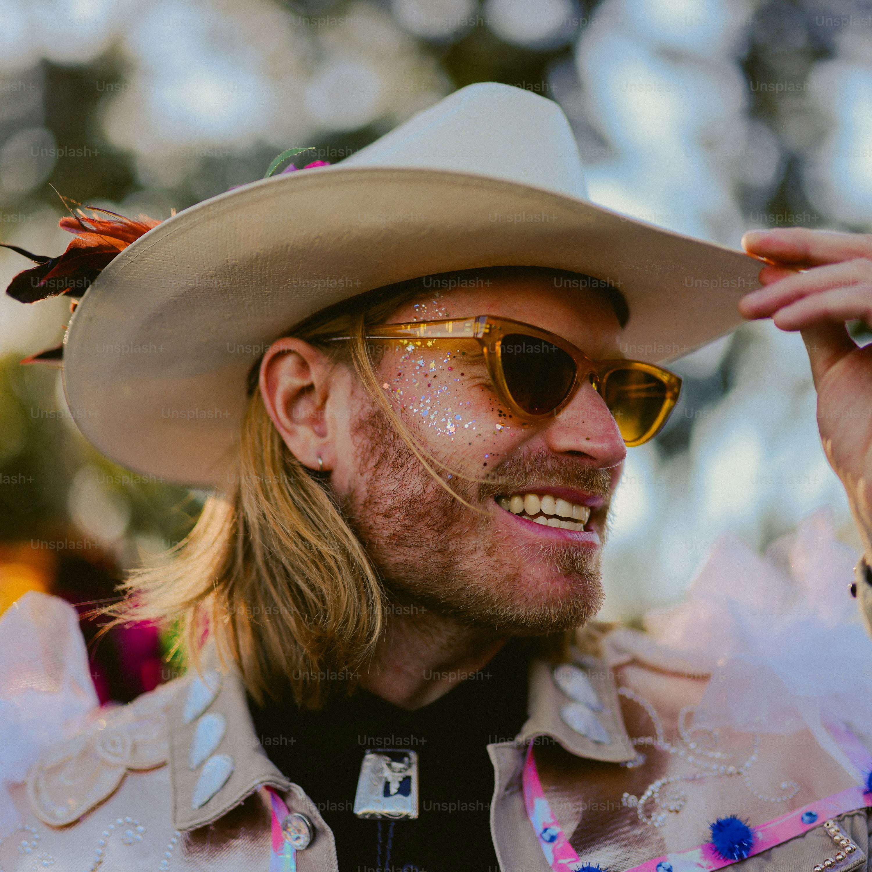 A man wearing a cowboy hat and sunglasses