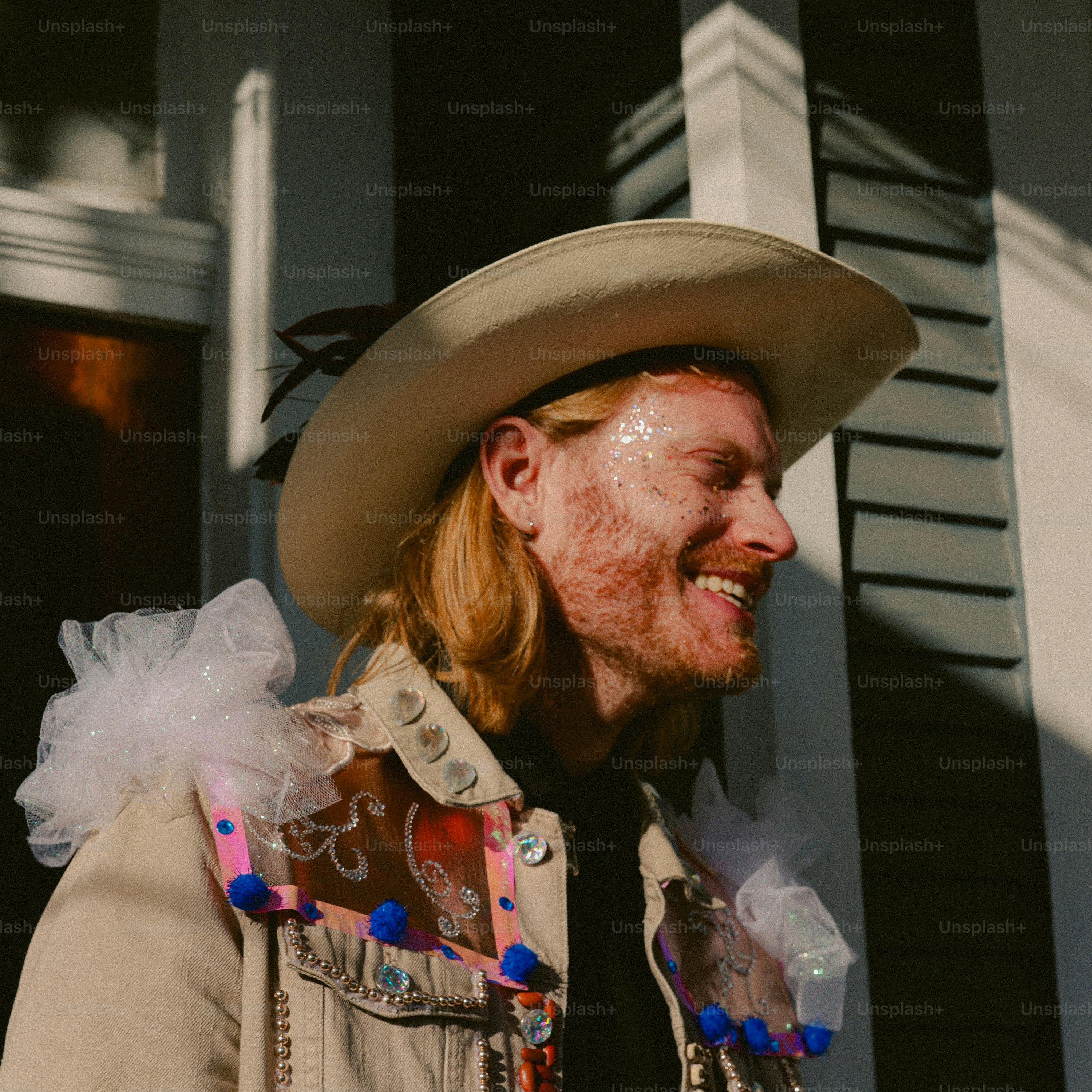 A man in a cowboy hat is smiling