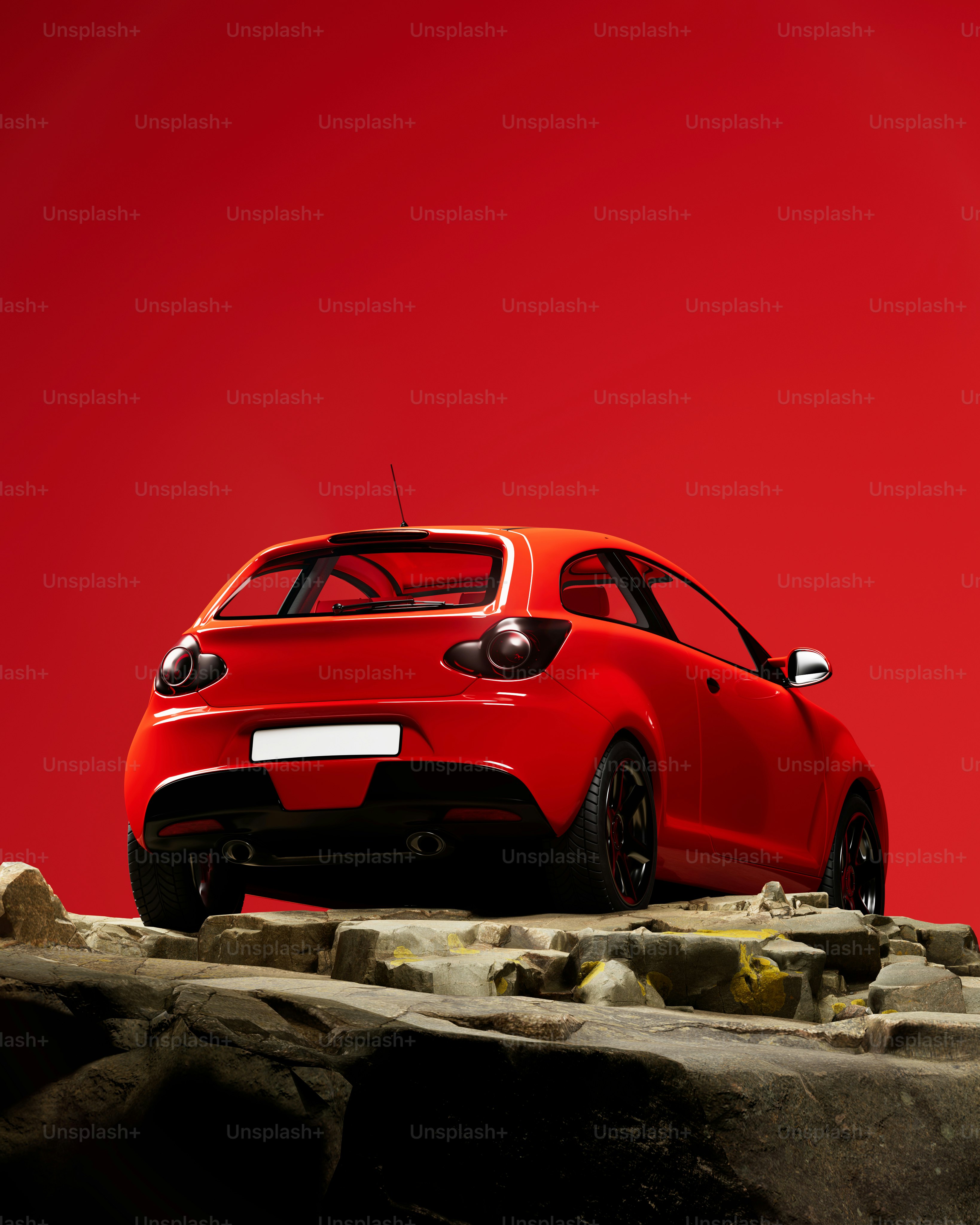 A red car is parked on a rock