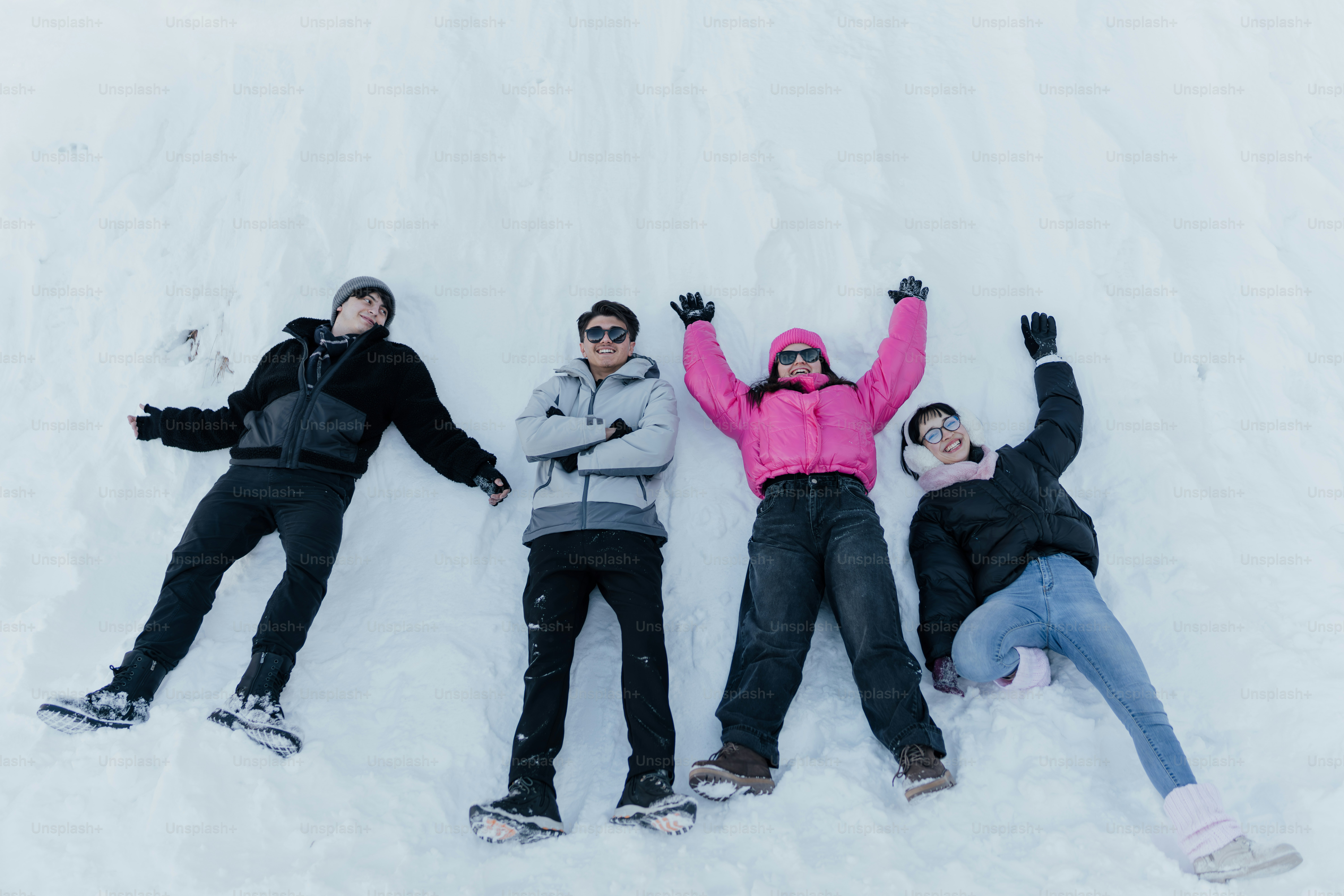 Un grupo de personas acostadas en la cima de una ladera cubierta de nieve