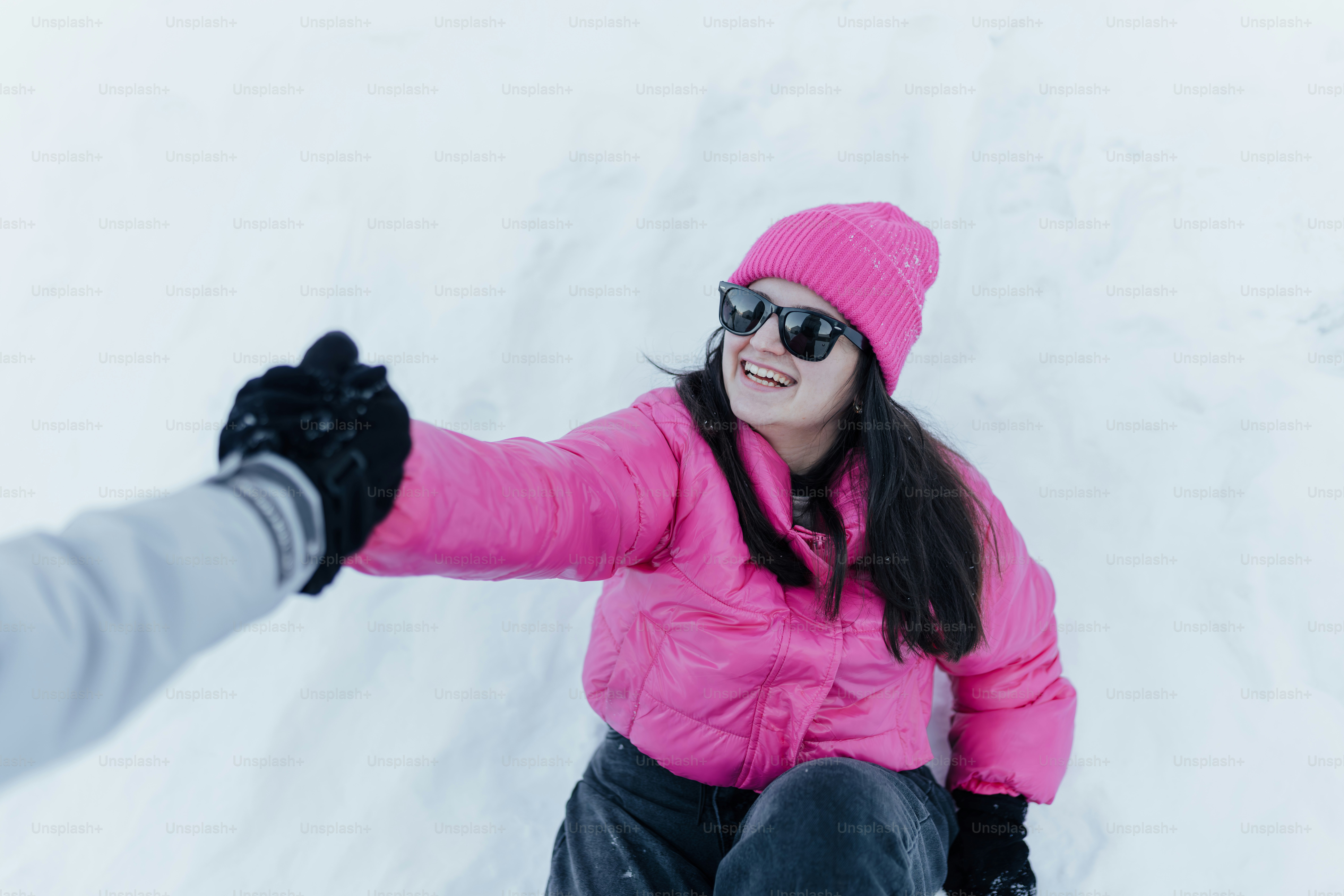 Una mujer montando una tabla de snowboard por una pendiente cubierta de nieve