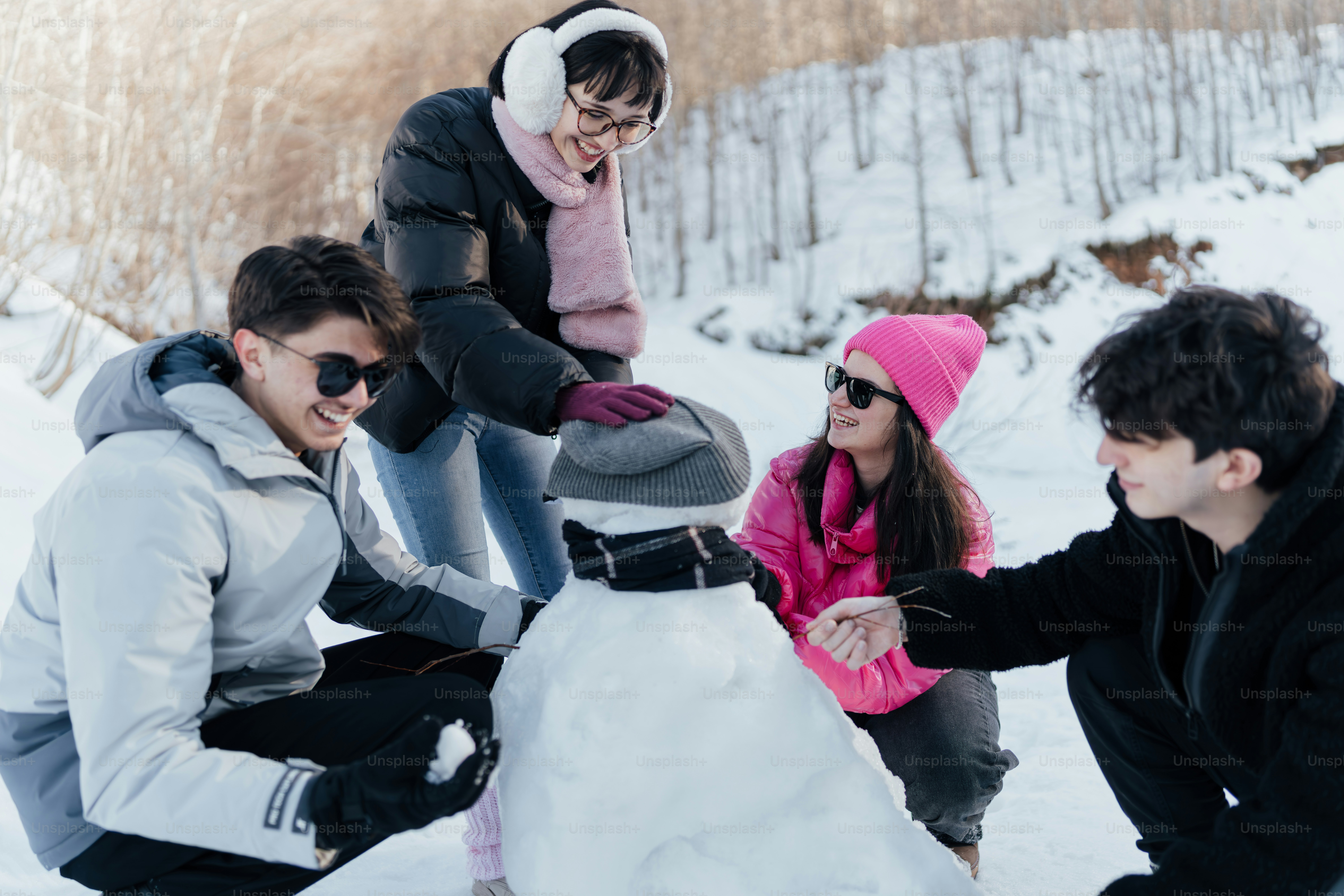 Un grupo de personas construyendo un muñeco de nieve en la nieve