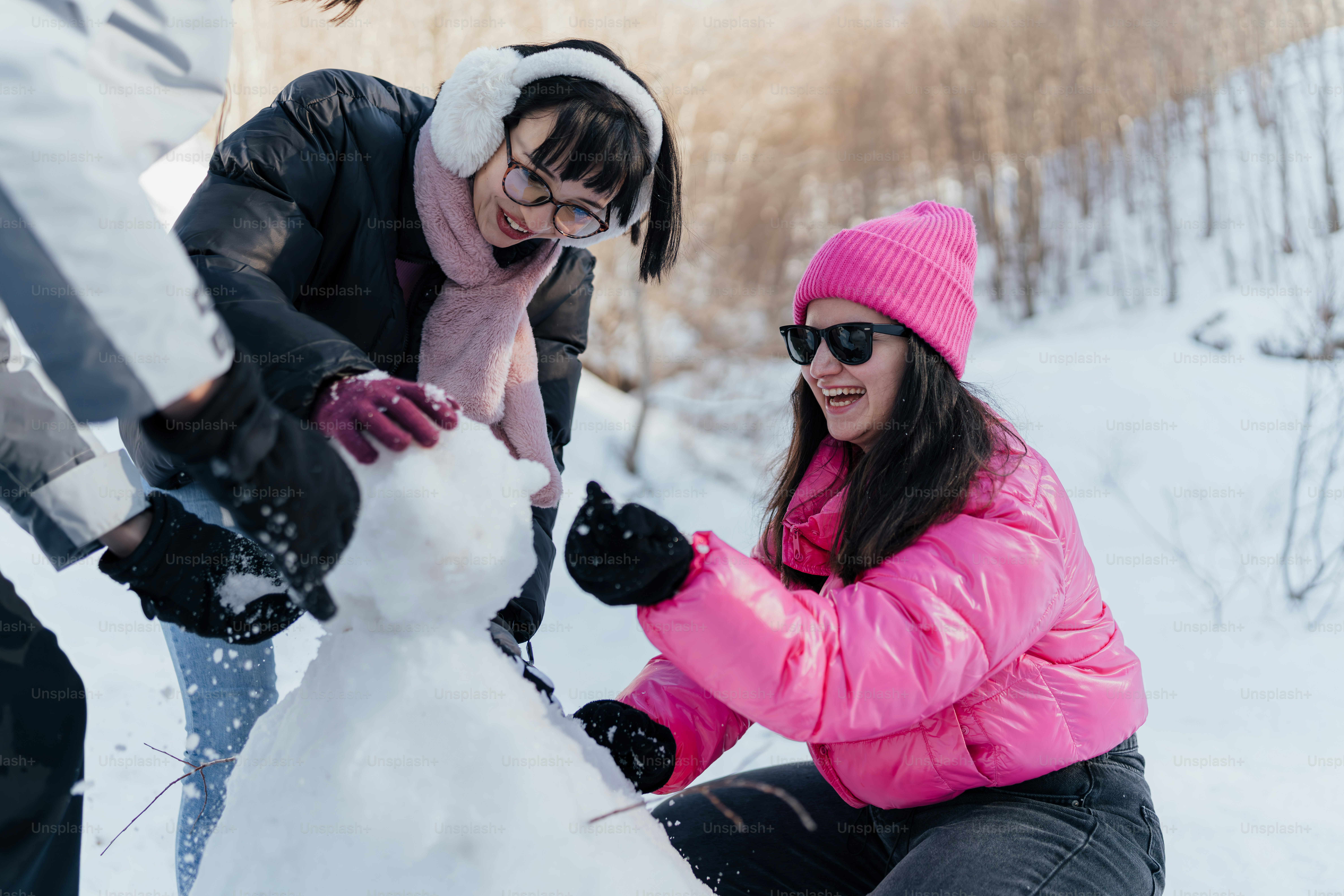 Un grupo de personas construyendo un muñeco de nieve en la nieve