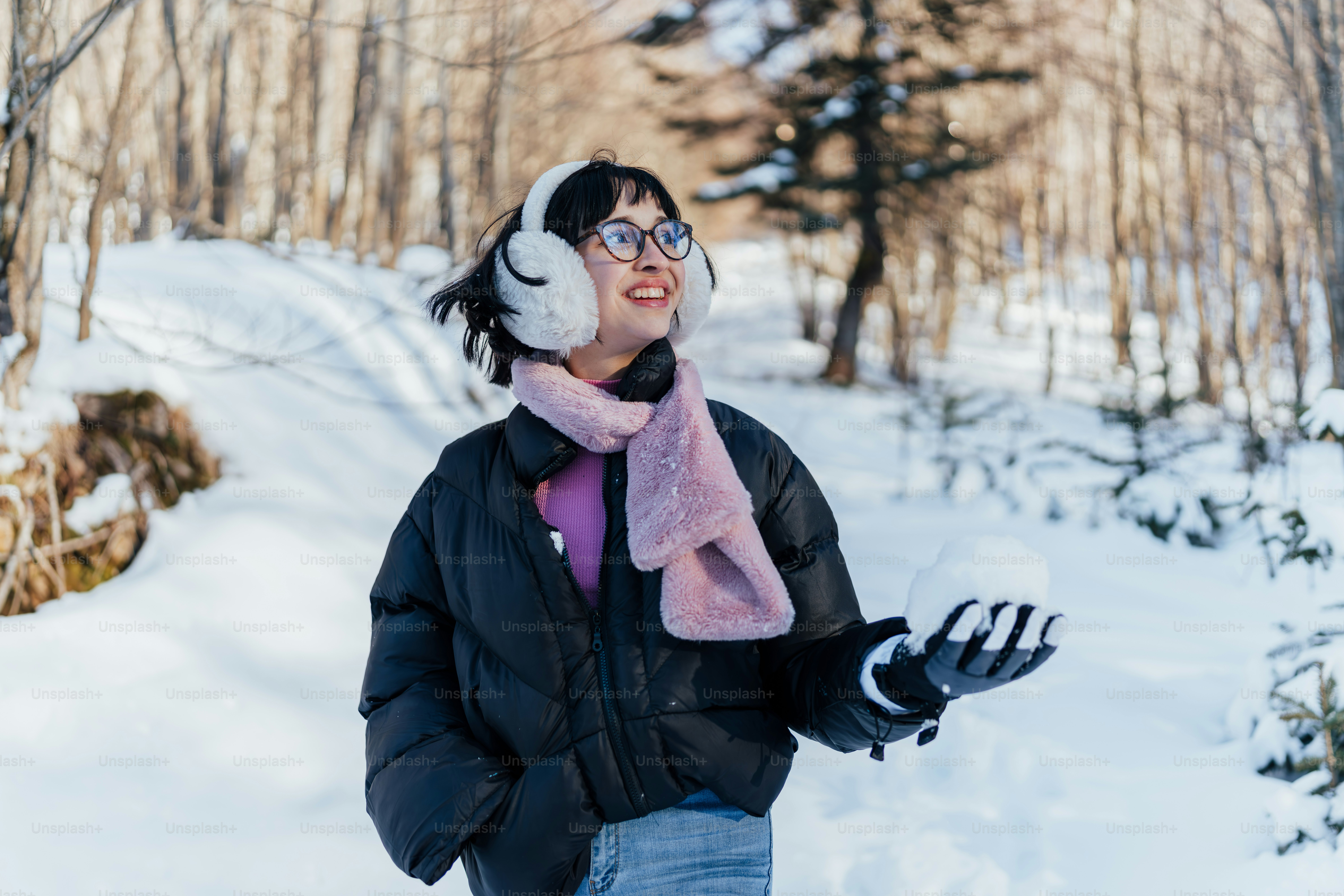 A woman walking through a snow covered forest
