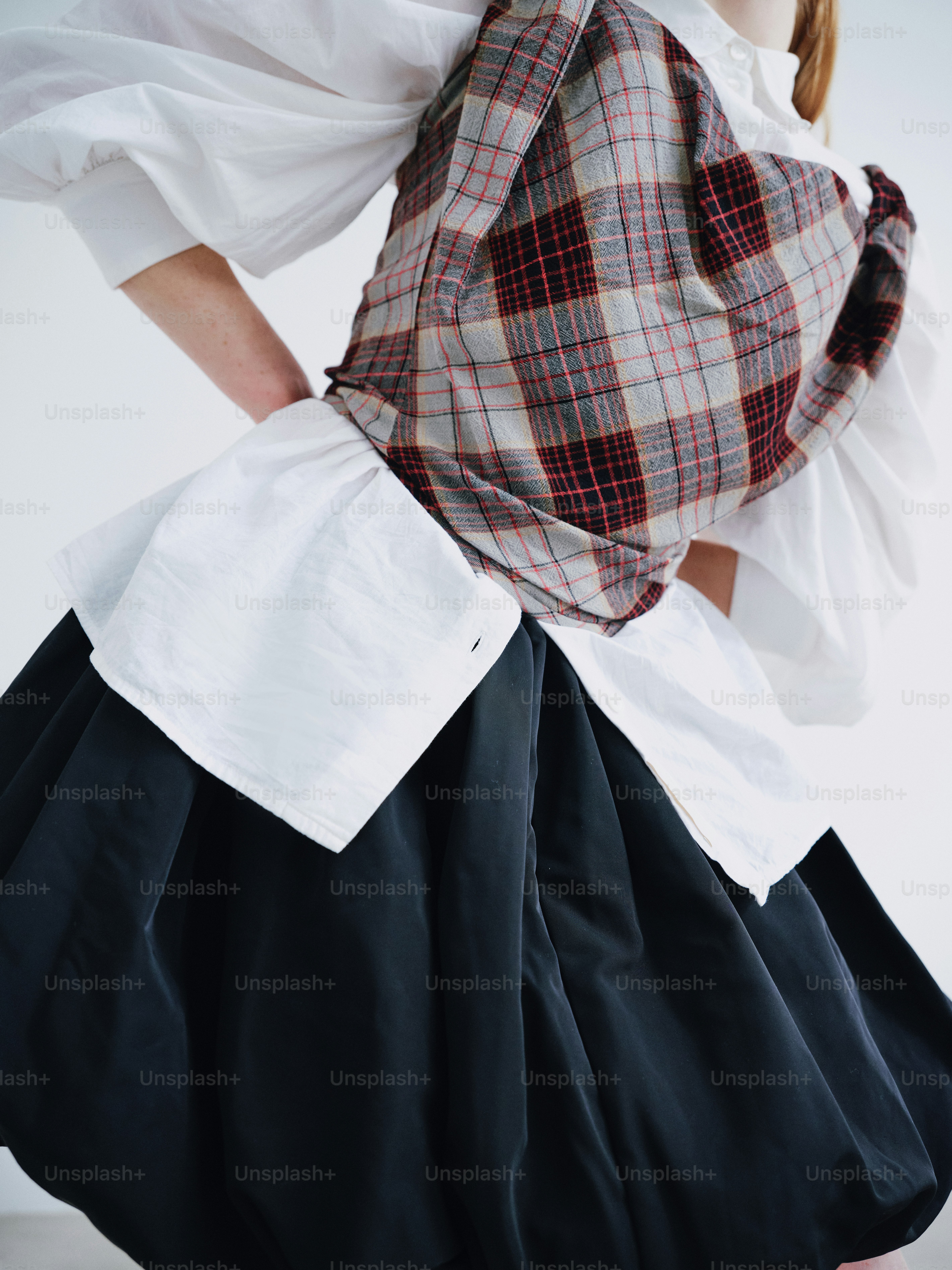 A woman in a white shirt and black skirt