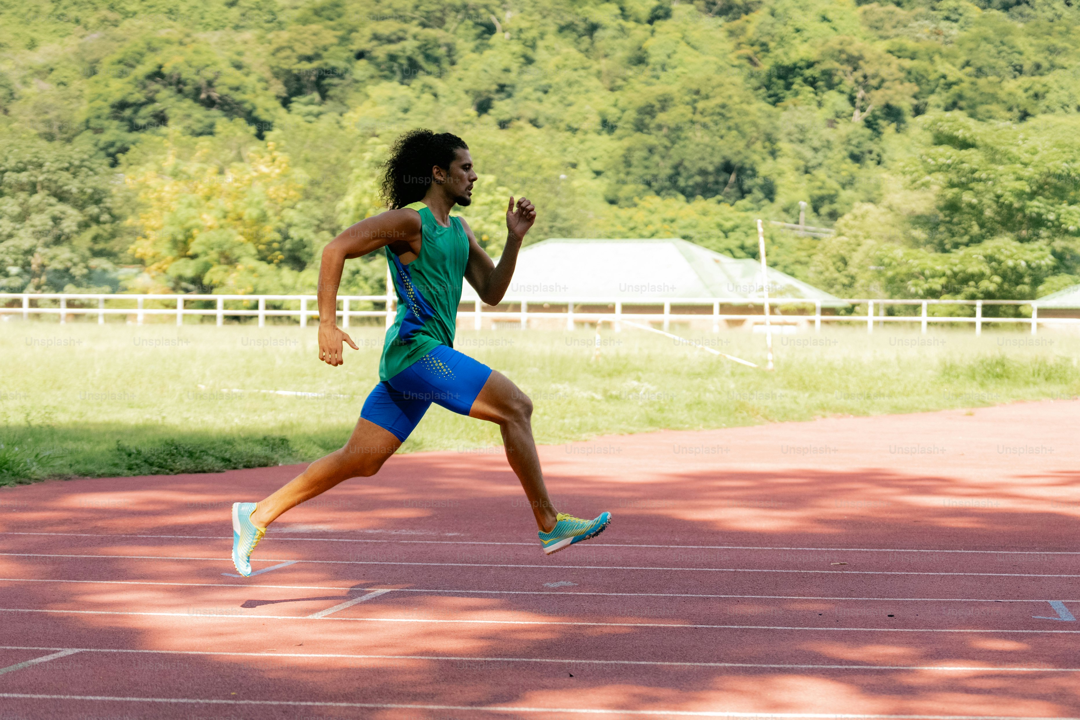 A man running on a track with trees in the background