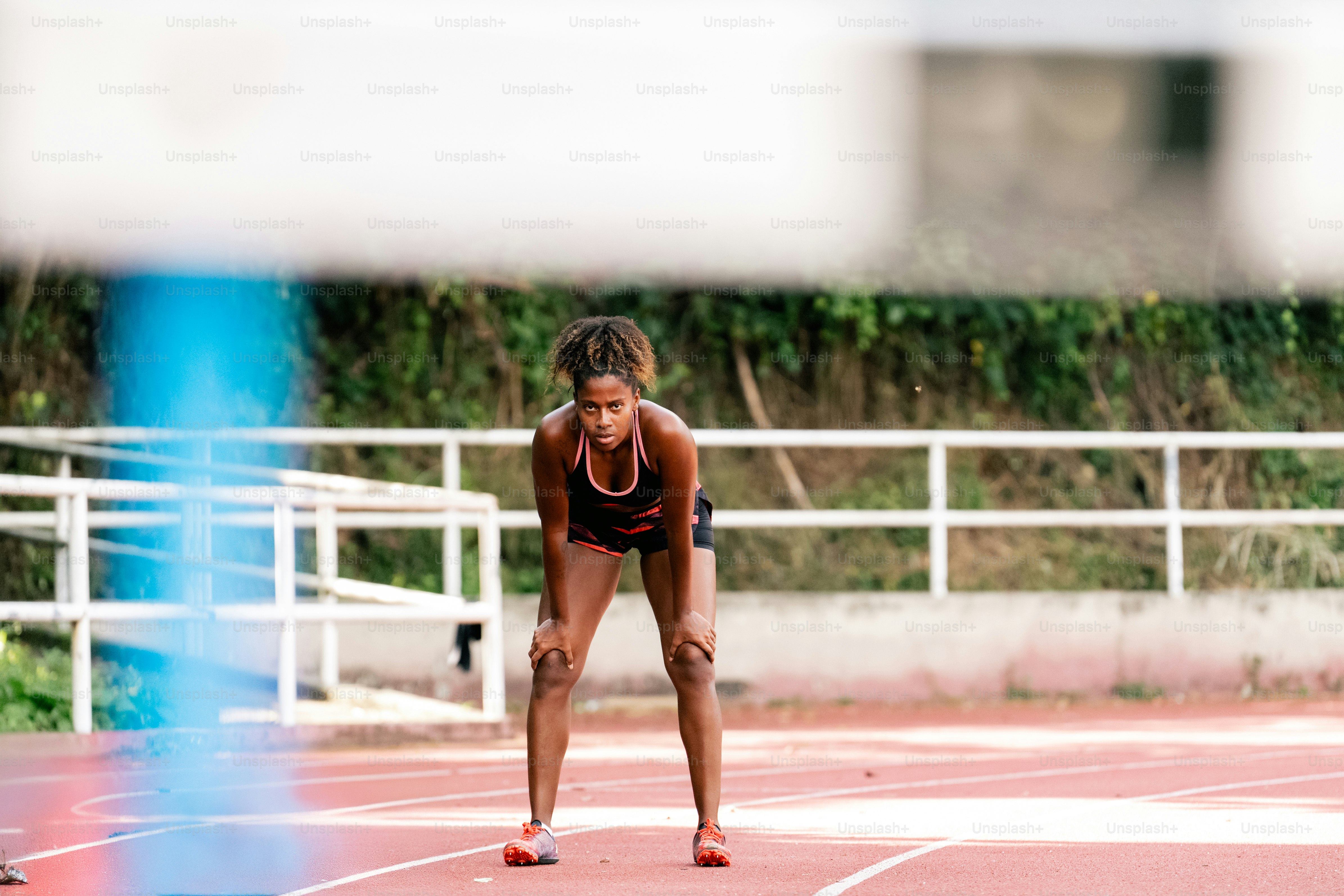 A woman standing on a track holding a tennis racquet